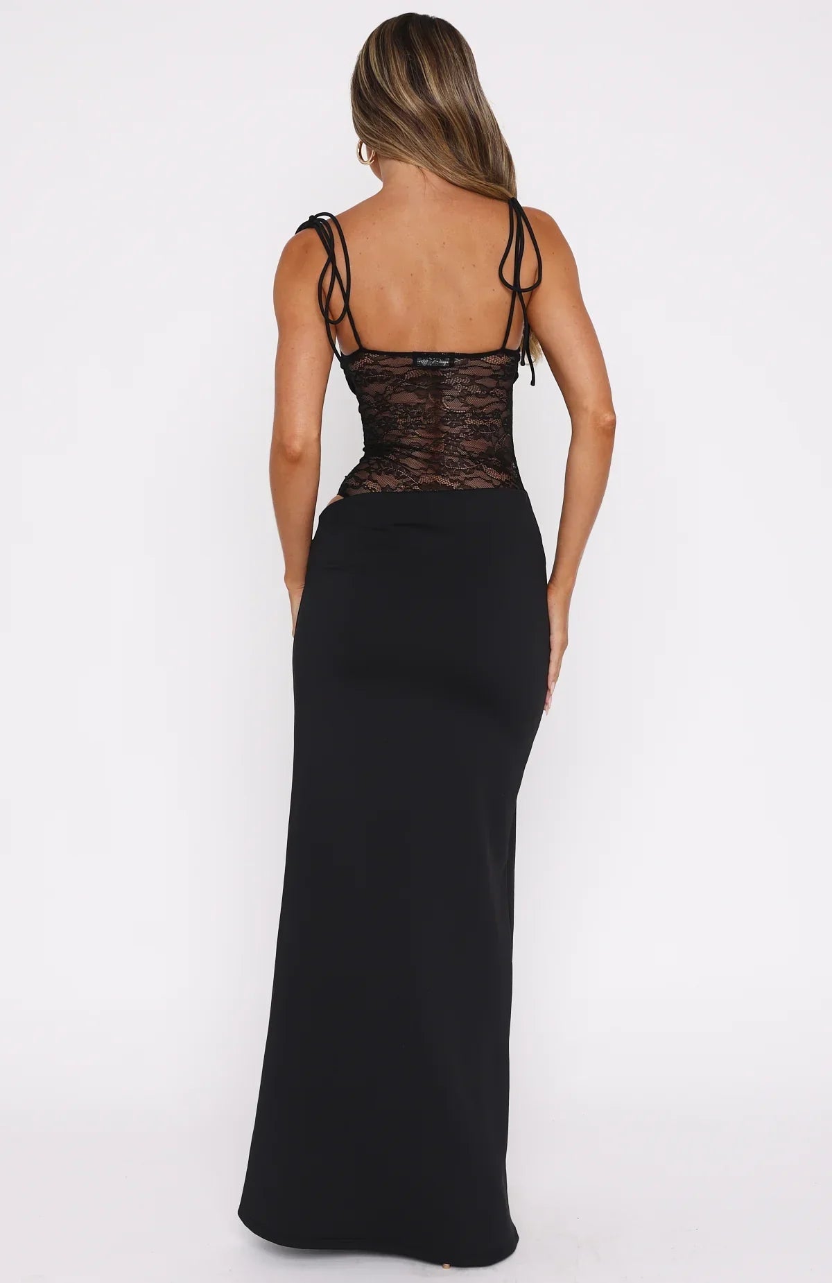 Back view of the black Abigail Lace Maxi Dress, featuring a sheer lace bodice with delicate spaghetti straps and a flowing floor-length skirt.