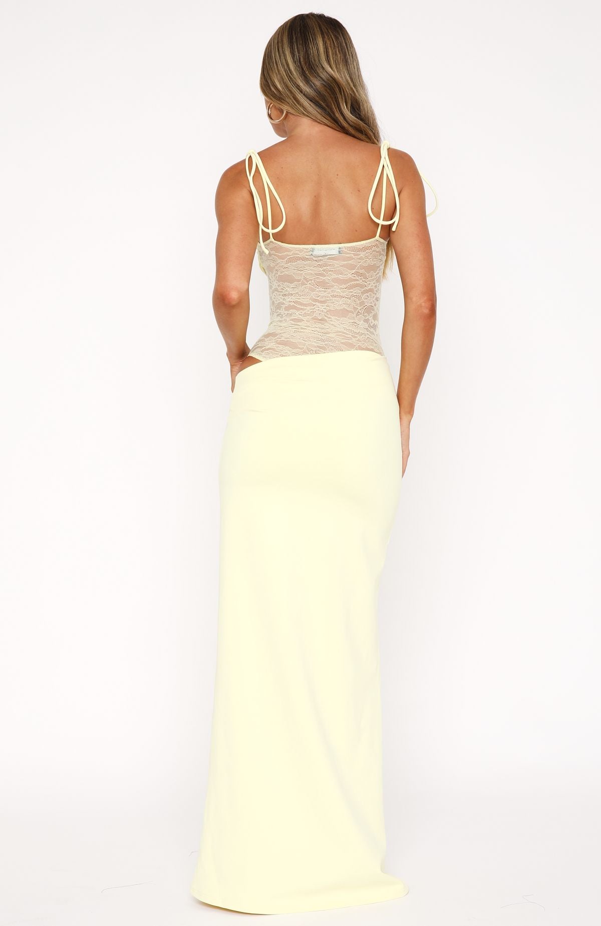 Back view of the pale yellow Abigail lace maxi dress, showing the tie-shoulder straps and fitted silhouette.