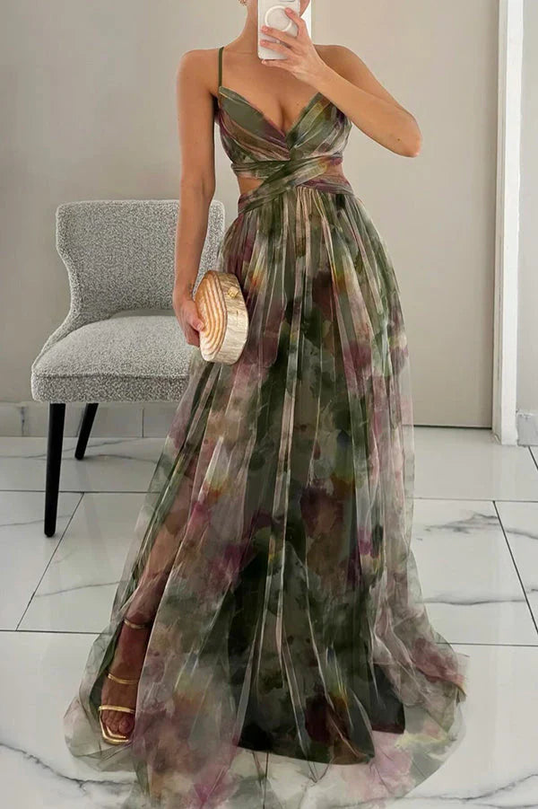 Green Addison Watercolor Maxi Dress with subtle purple and pink tones, featuring a side slit and a unique wooden clutch.