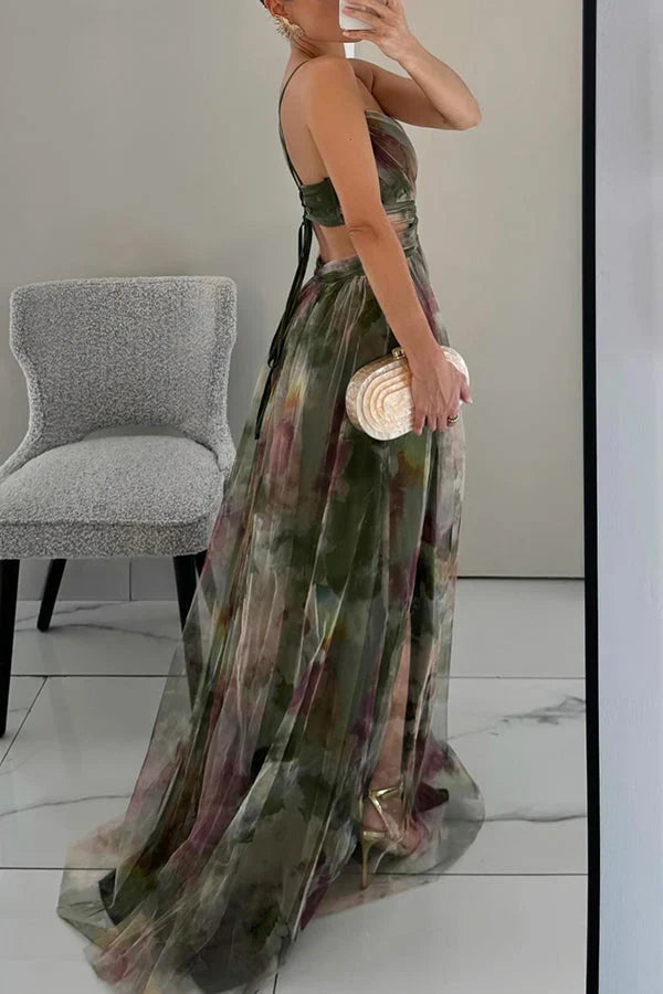 Side profile of the green Addison Watercolor Maxi Dress, showing the flowing skirt, back strap detail, and gold heels.
