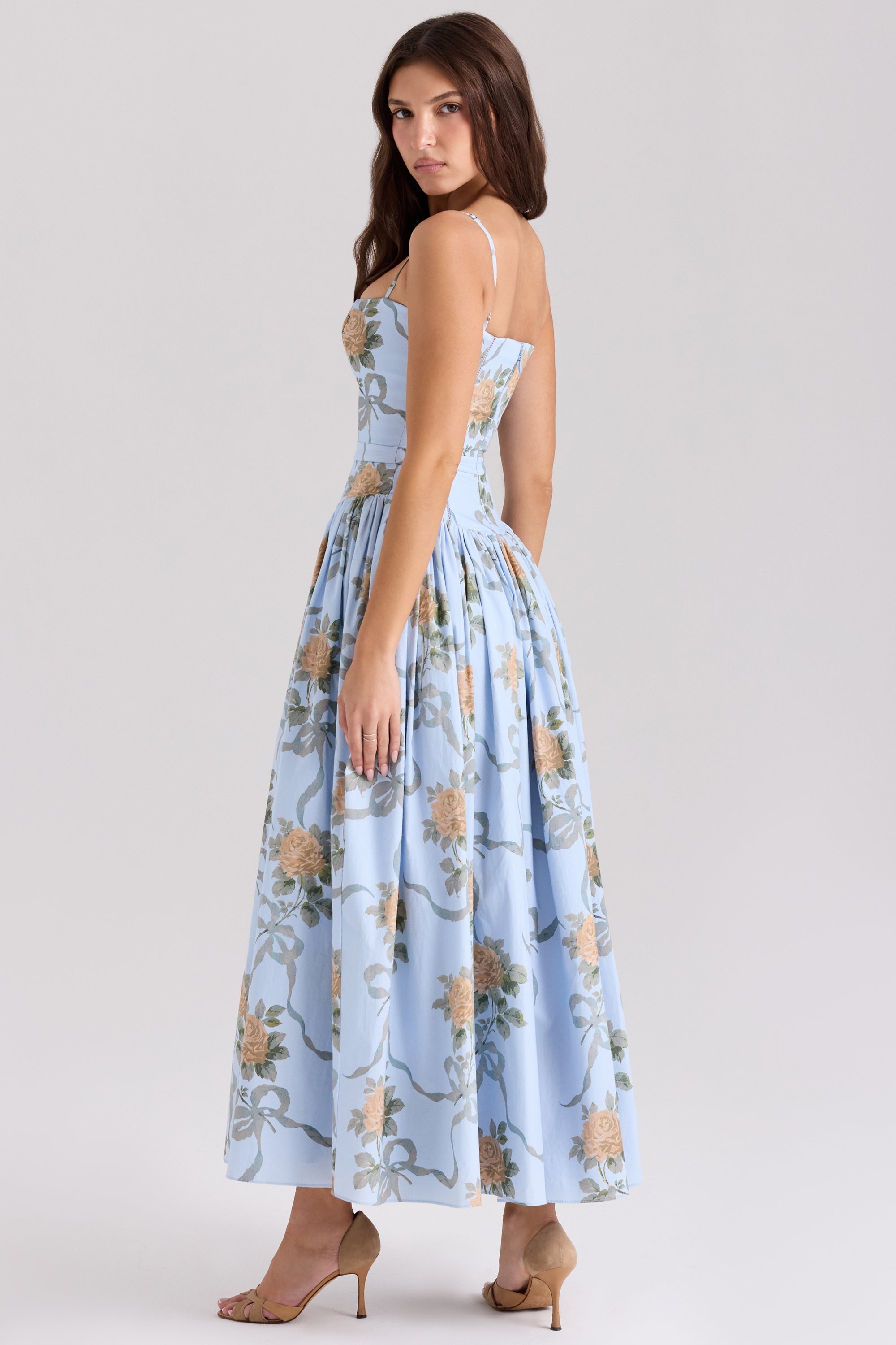 Back view of the light blue Adeline Corset Midi Dress, showcasing the peach rose and ribbon pattern and full skirt.
