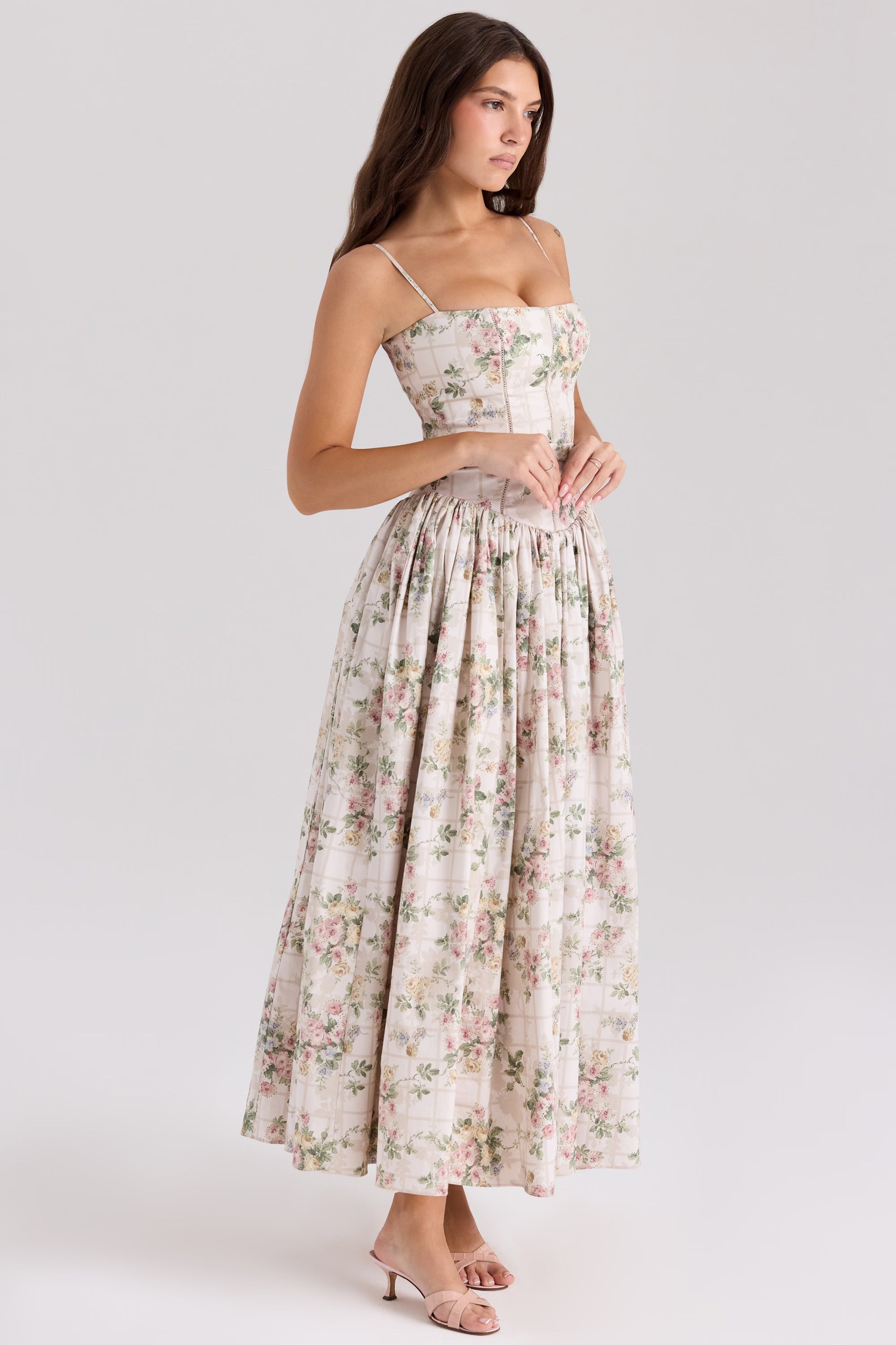 Side profile of the off-white Adeline Corset Midi Dress, highlighting the structured corset and flowing floral skirt.