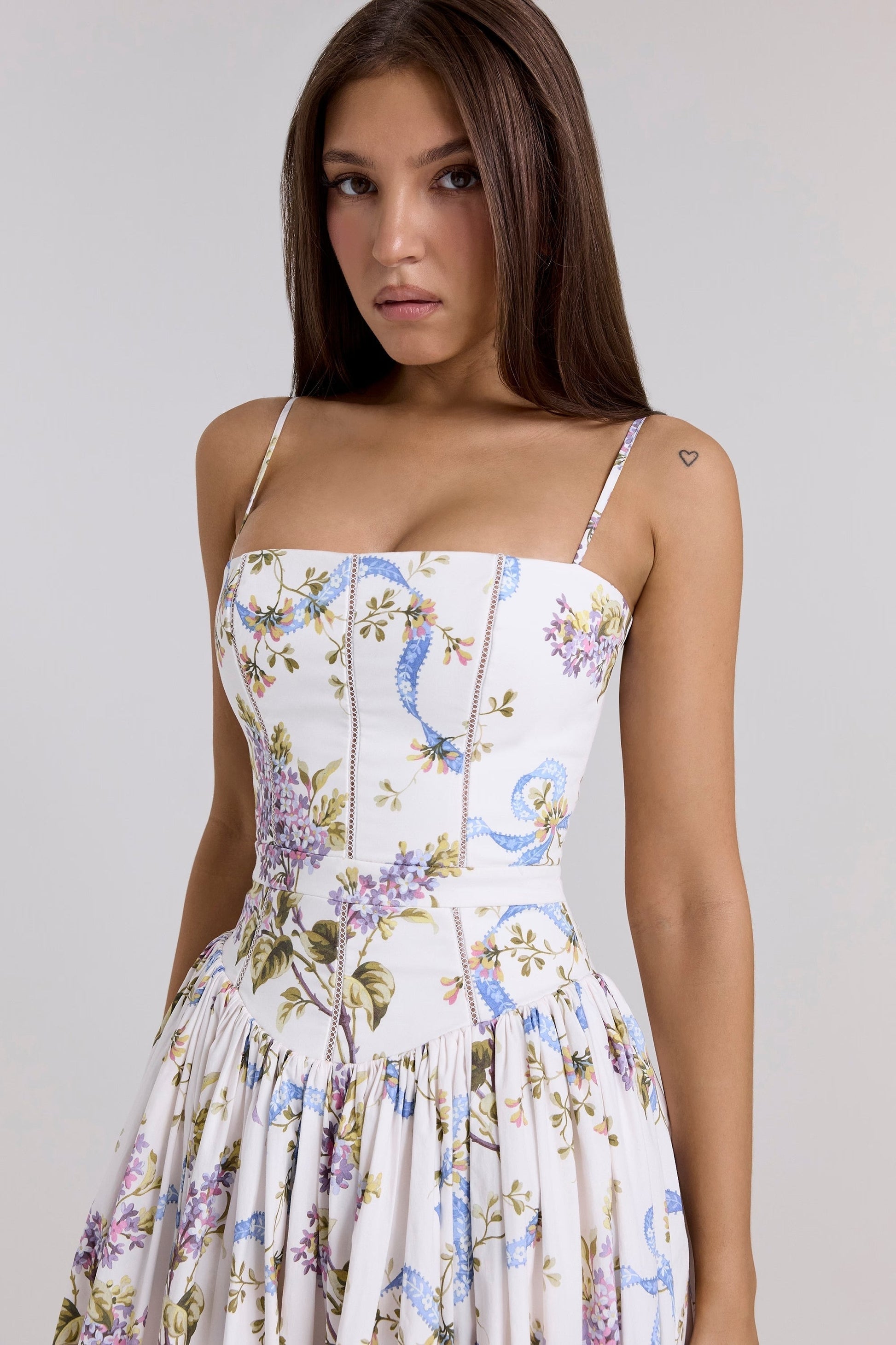 Close-up of the bodice on the Adeline Corset Midi Dress, showing the purple floral and blue ribbon print details and corset stitching.