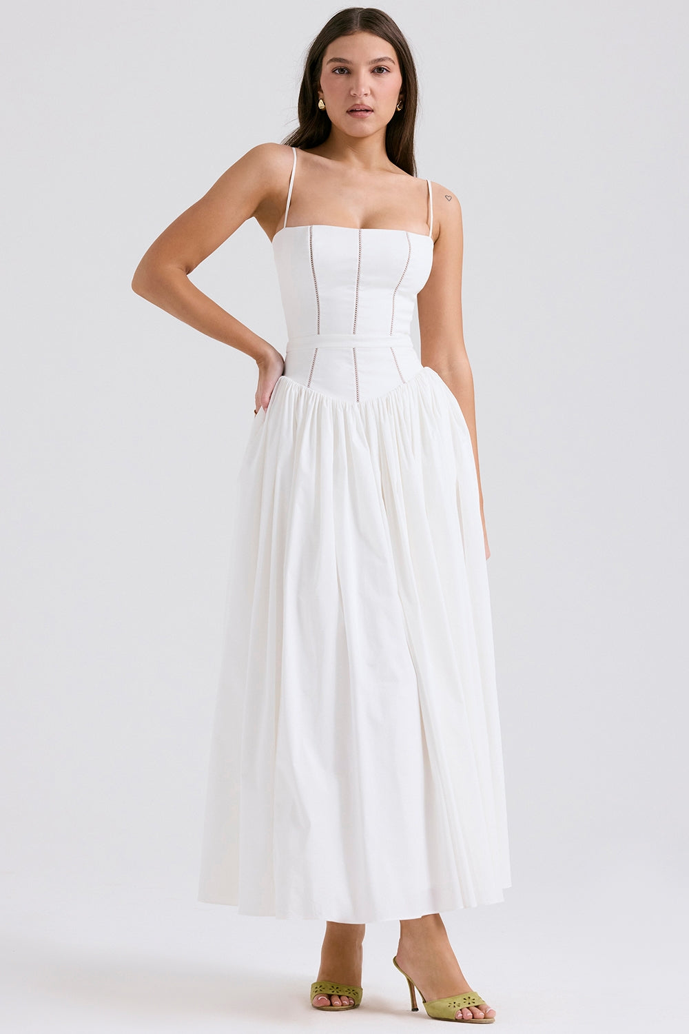 Plain white Adeline Corset Midi Dress with a structured bodice, wide gathered skirt, and green heeled slides.