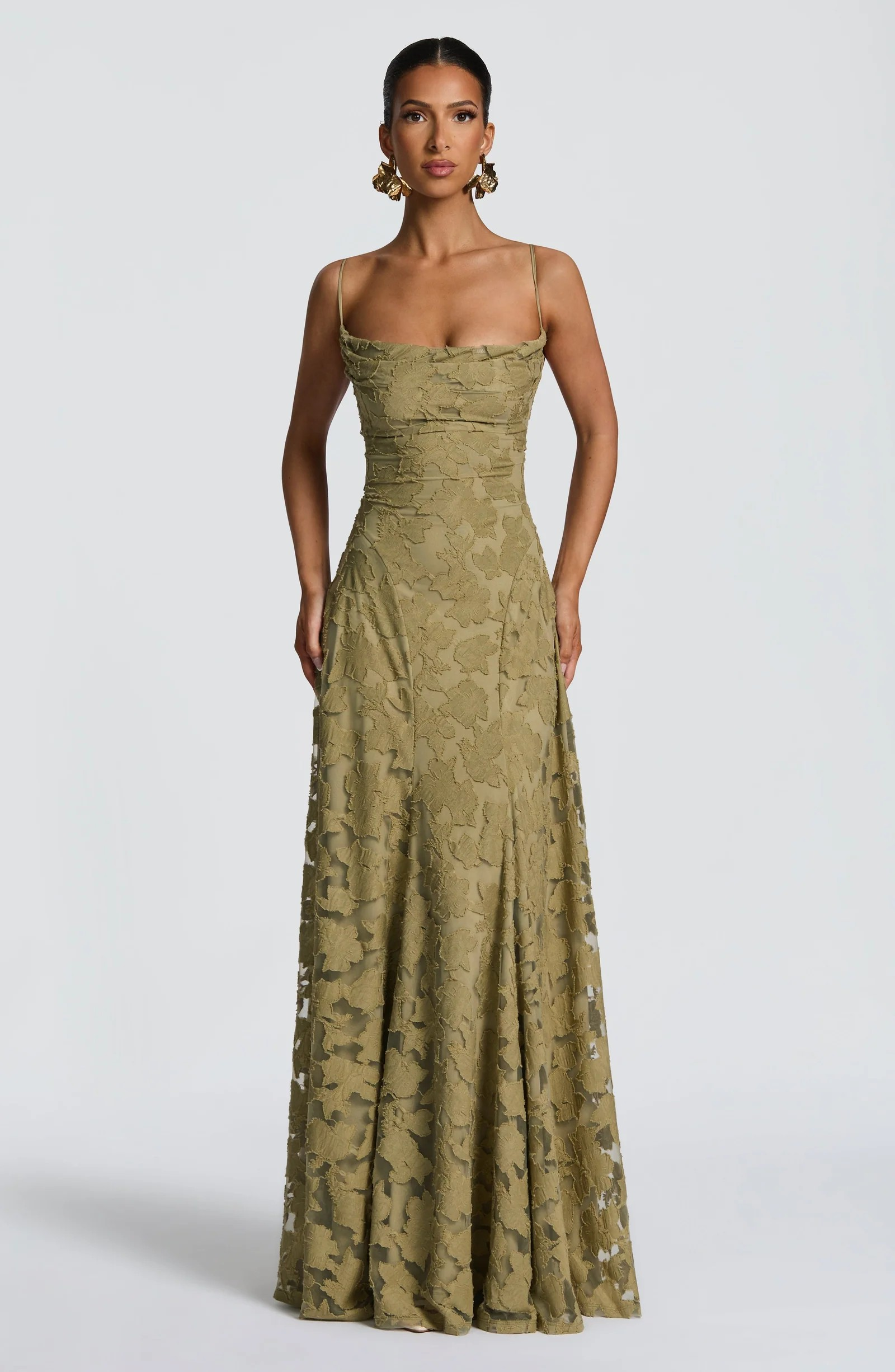 Front view of a long Adrianna Floral Maxi Dress in a light olive green, featuring a subtle floral pattern and spaghetti straps.
