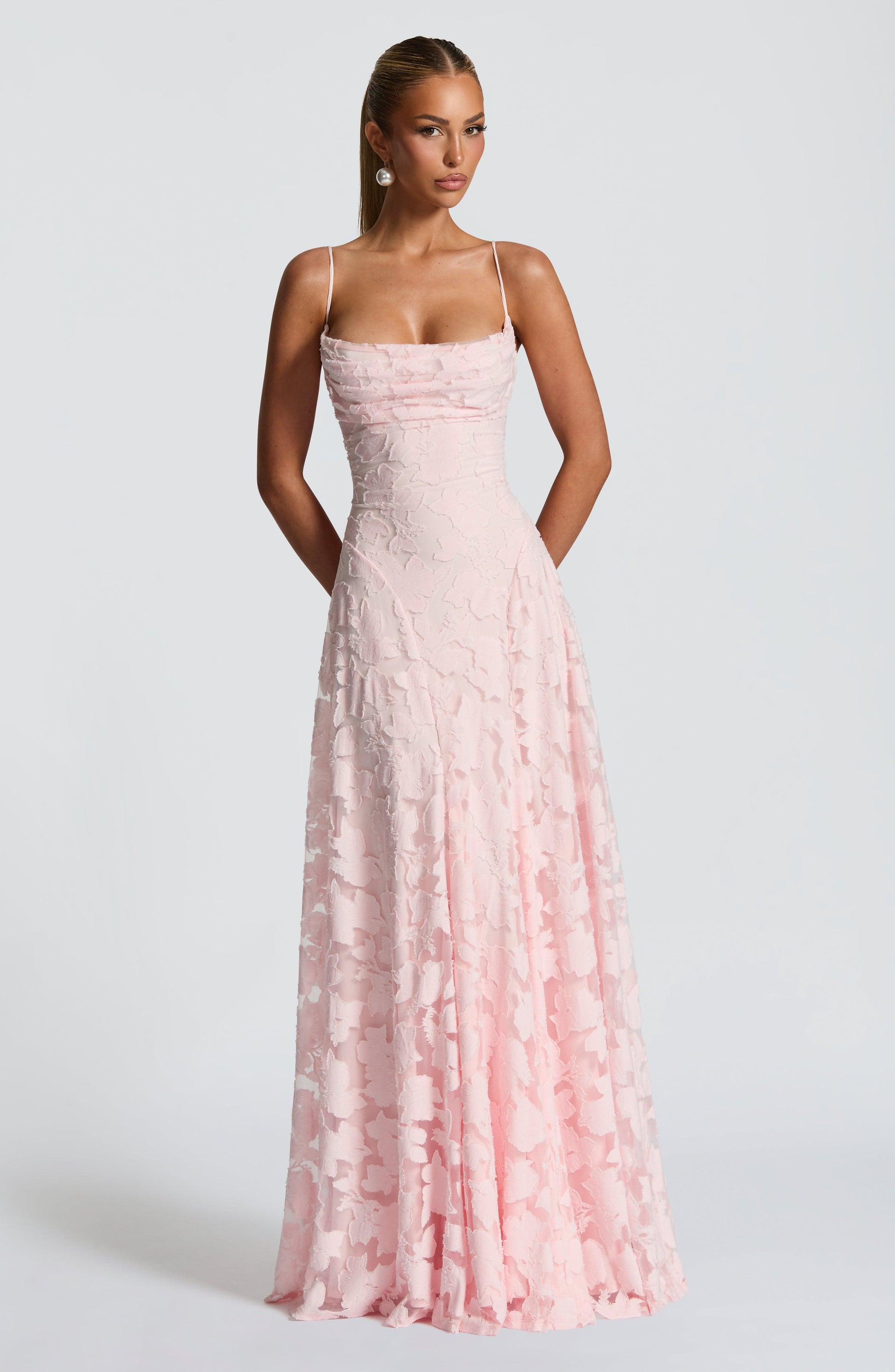 Front view of a light pink floral maxi dress with delicate spaghetti straps and a flowing skirt.
