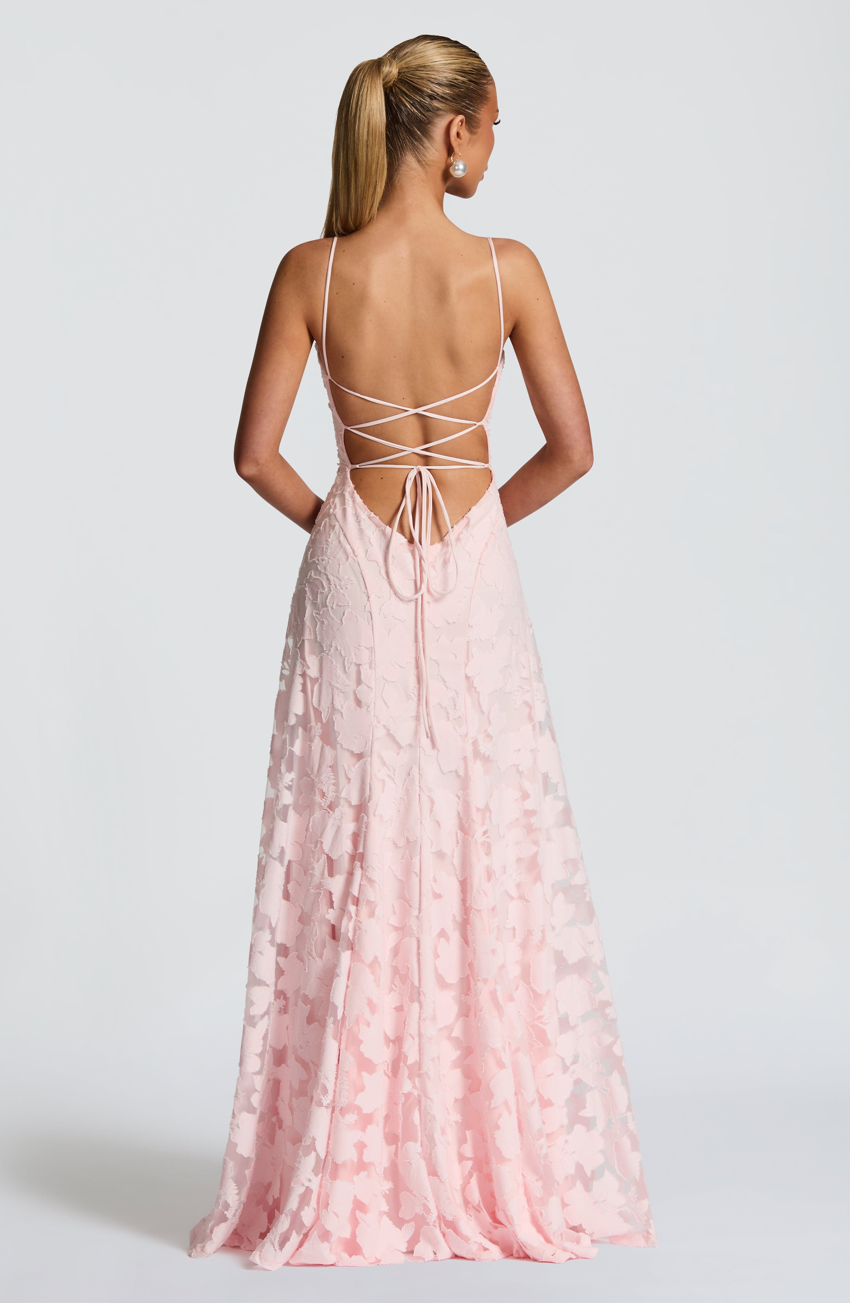 Back view of the pink floral maxi dress, featuring a lace-up back design with thin straps.
