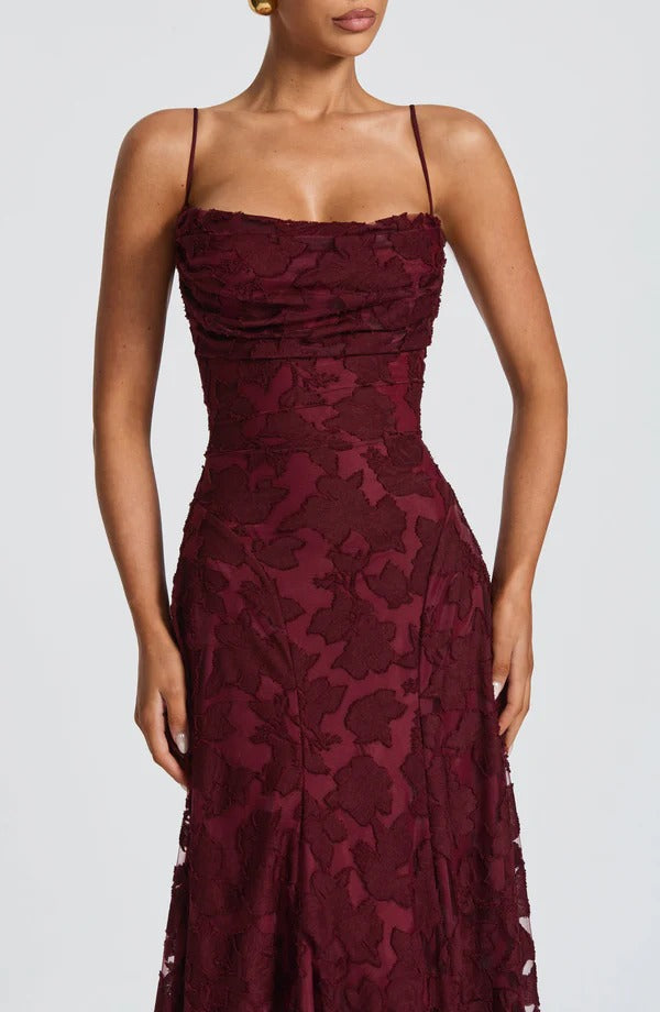 Close-up of the rich burgundy floral maxi dress, highlighting the textured floral pattern on the fabric.