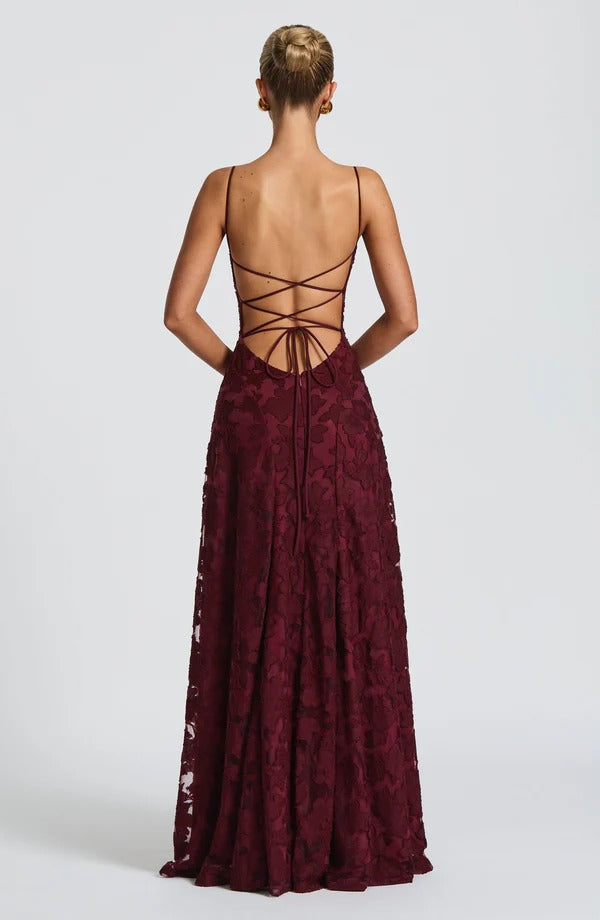Back view of the burgundy floral maxi dress, showcasing the intricate lace-up detail and flowing skirt.