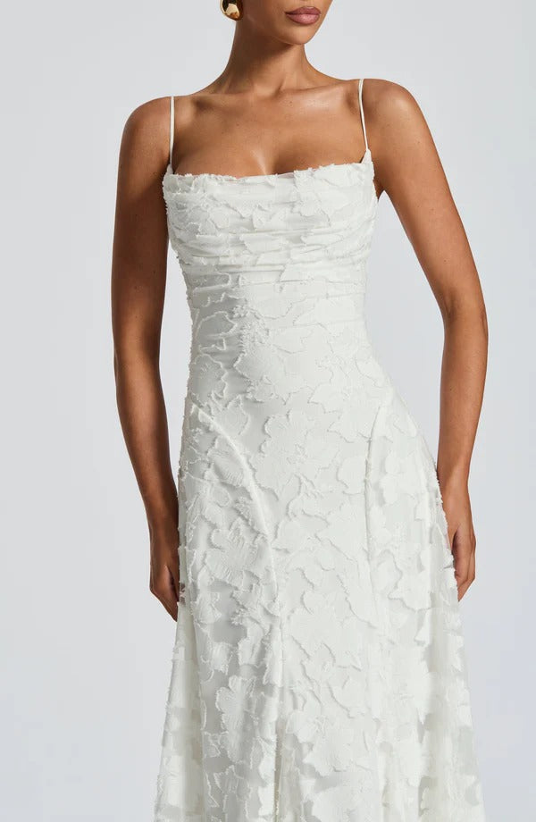Close-up of the white floral maxi dress, detailing the textured floral design and the fitted top.