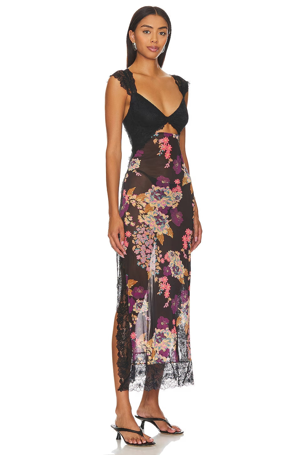Side view of Aisha backless maxi dress in black with vibrant floral print, lace bust, and high leg slit.