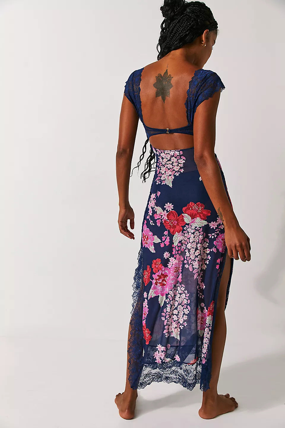 Back view of a navy blue Aisha backless maxi dress with pink and red floral patterns and delicate lace trim.