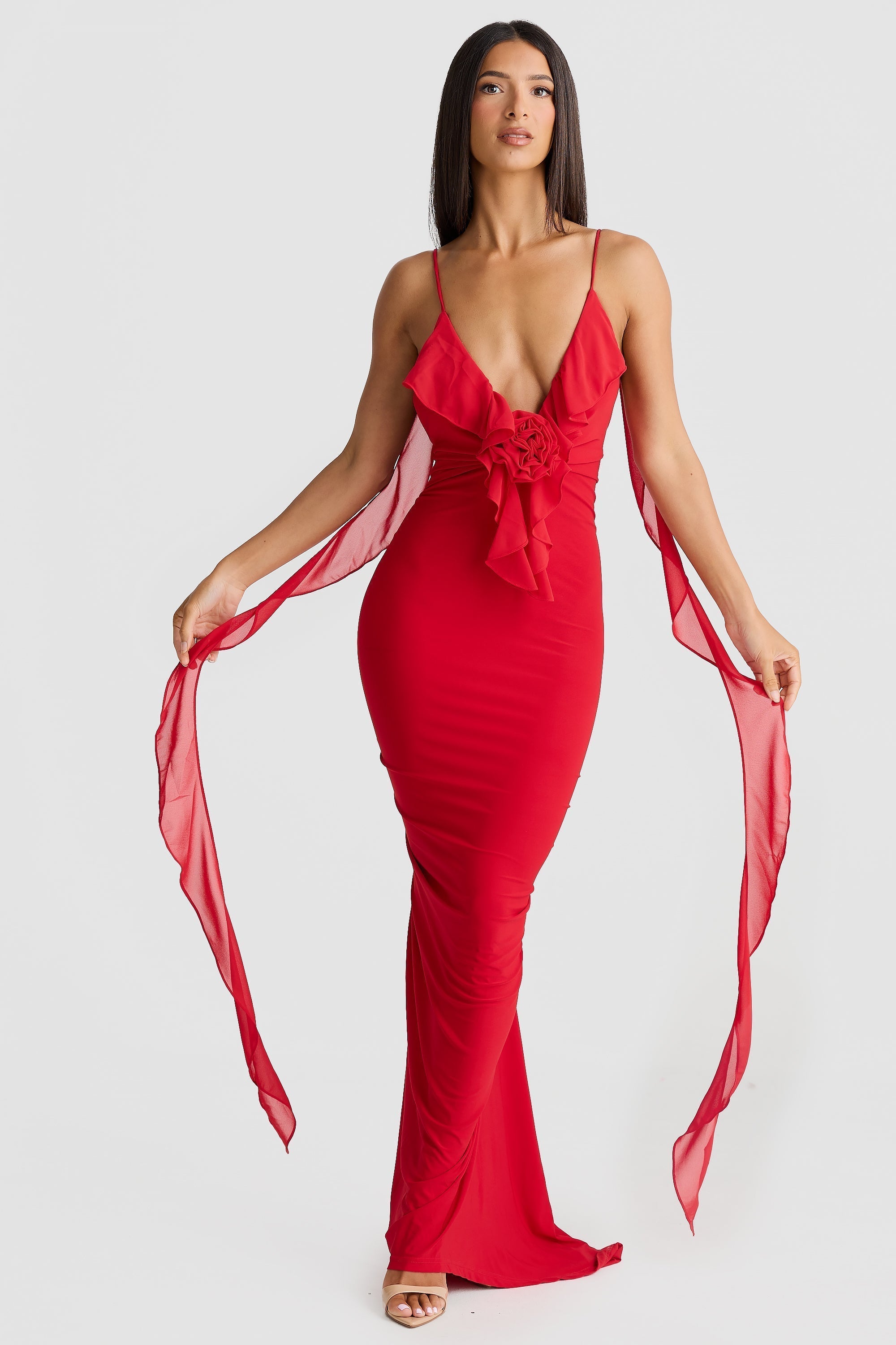 Front view of a vibrant red Alexa Ruffle Maxi Dress, showcasing the V-neckline, ruffled bust detail, and long sheer chiffon sashes.
