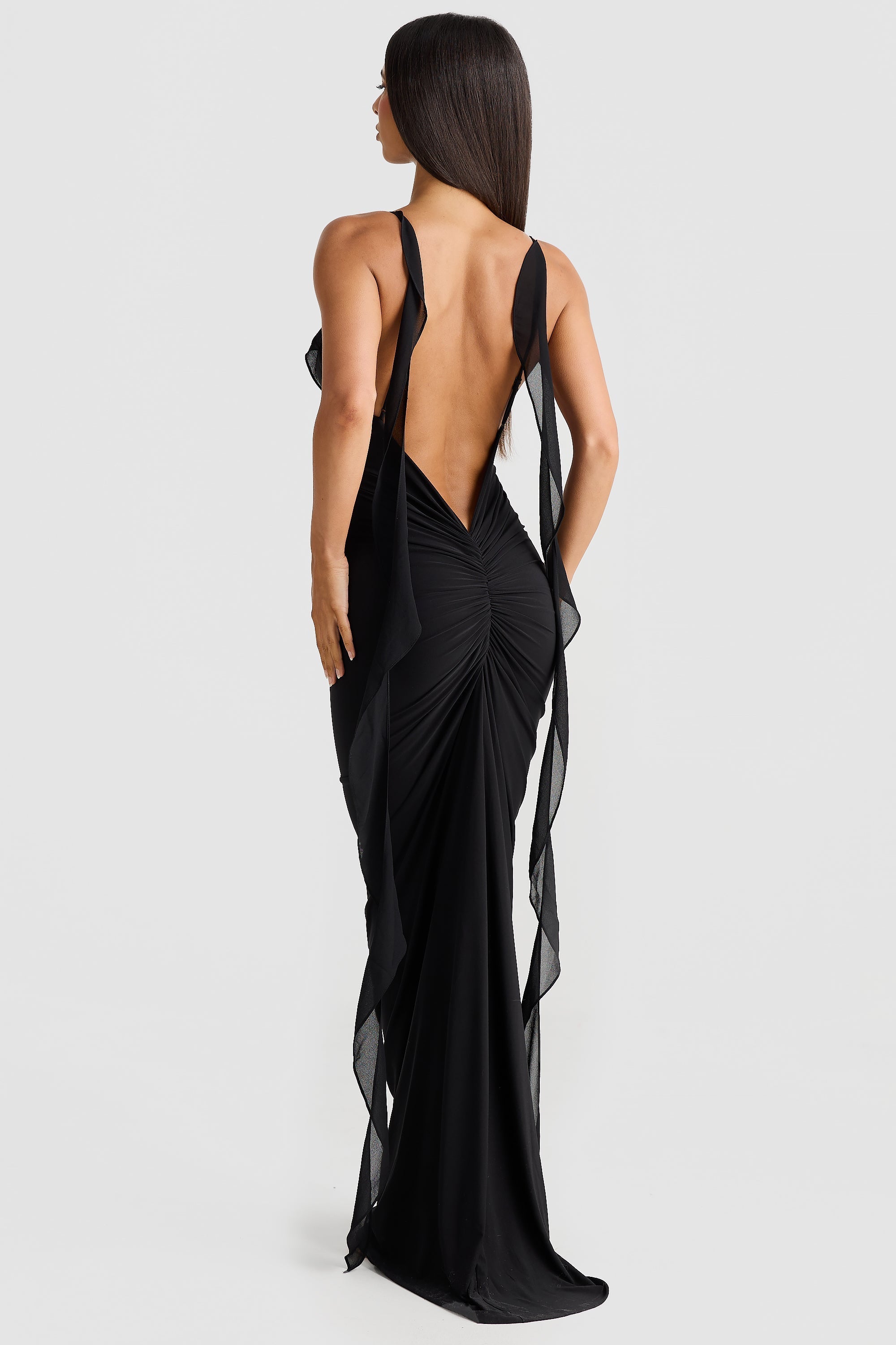 Back view of the black Alexa Ruffle Maxi Dress, displaying the elegant open back, gathered skirt, and sheer chiffon straps.
