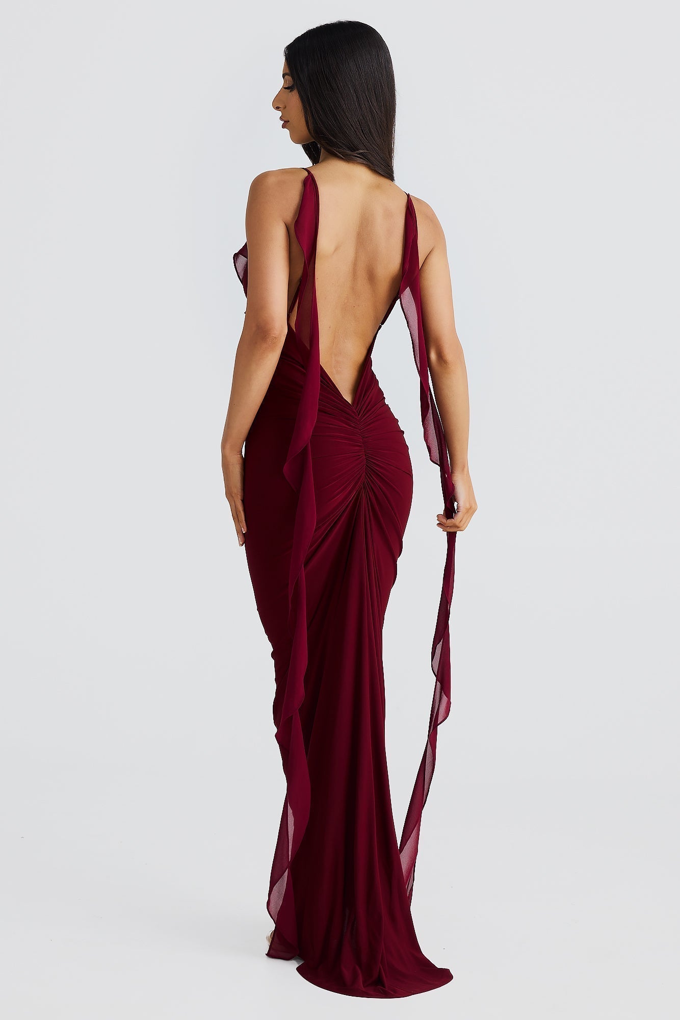Back view of the burgundy Alexa Ruffle Maxi Dress, highlighting the open back design with ruched detailing on the skirt and flowing chiffon straps.