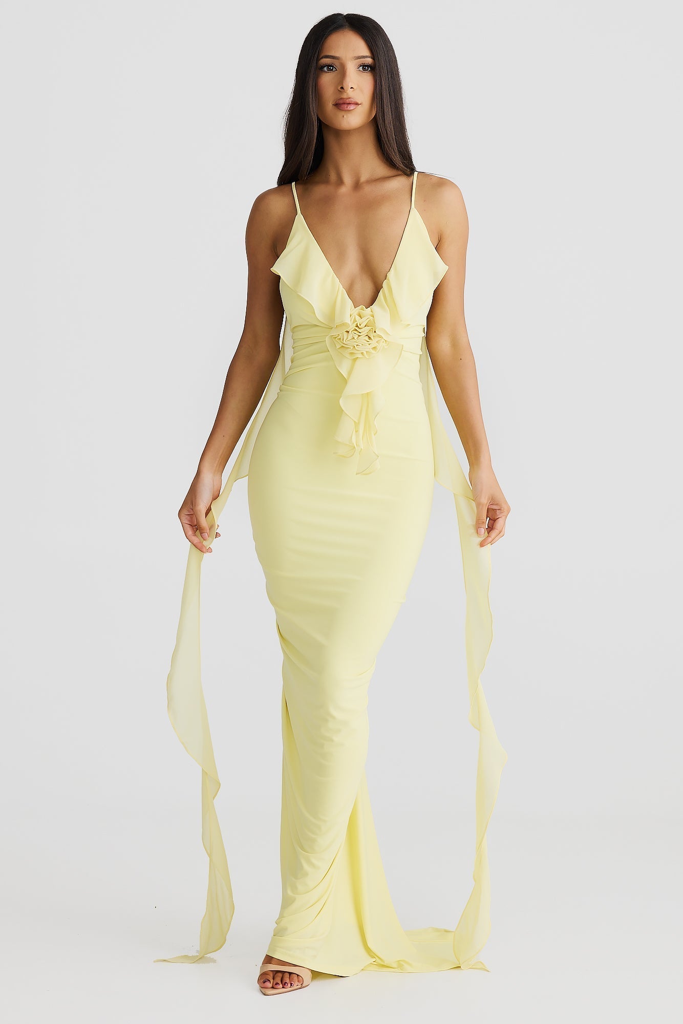 Front view of a light yellow Alexa Ruffle Maxi Dress with a deep V-neck and delicate shoulder straps, featuring a ruffled bodice and long flowing chiffon sashes.