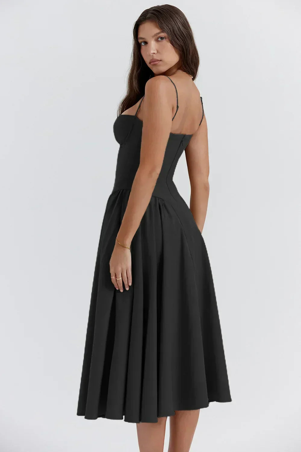 Back three-quarter view of an all black corset midi dress, highlighting the structured bodice and pleated skirt.