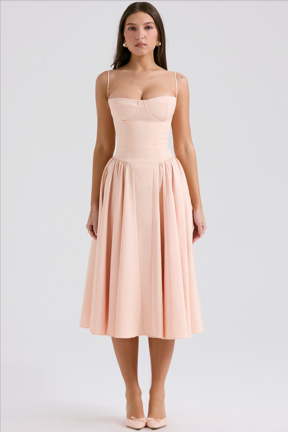 Front view of a light pink corset midi dress with a sweetheart neckline and a voluminous pleated skirt.