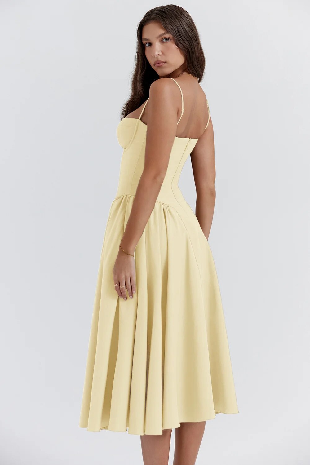 Back view of the pale yellow Alexandra corset midi dress, displaying the elegant pleated skirt and delicate straps.