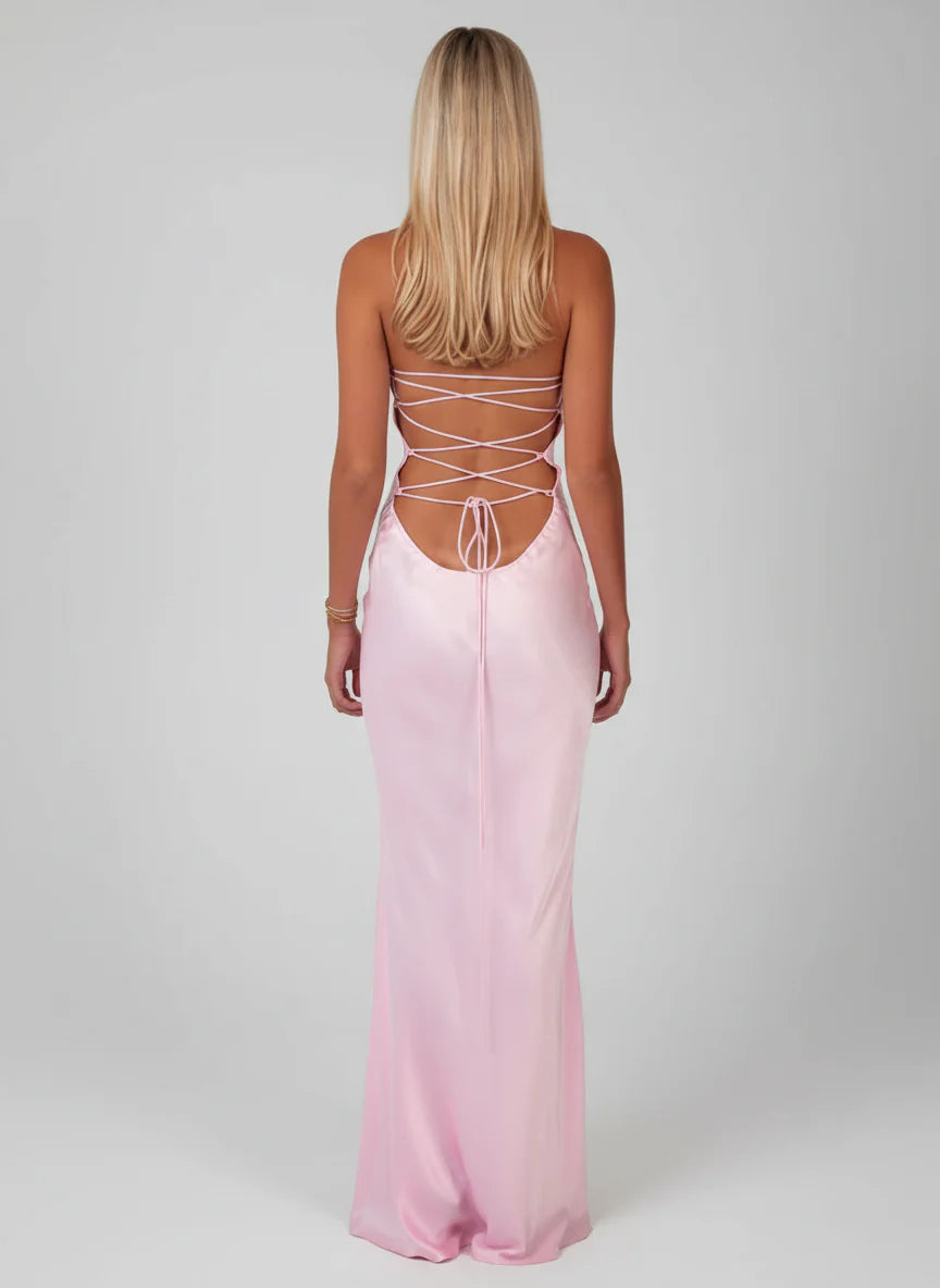 Back view of the light pink satin halter maxi dress, showcasing the intricate lace-up back design and open back.