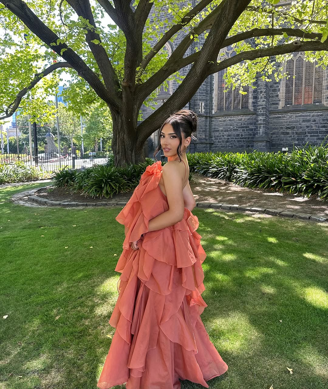 Side view of the peach Andrea Ruffle Maxi Dress, showing the layered ruffles and strapless design.