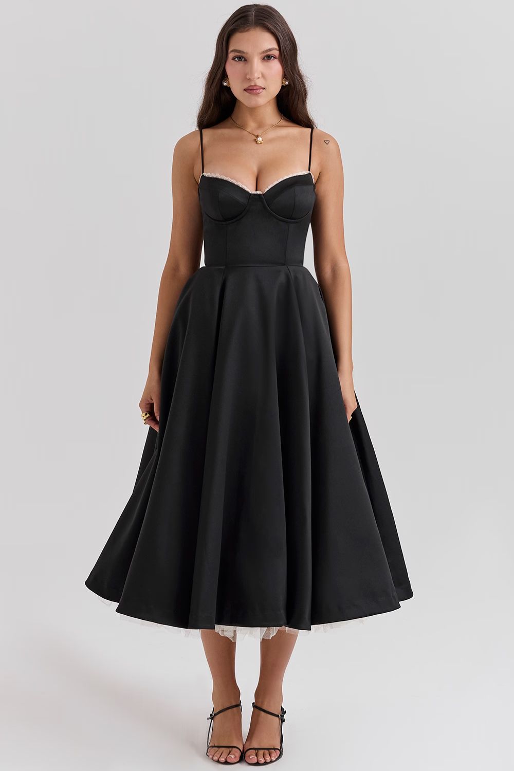 Front view of a black Angela Corset Midi Dress with delicate spaghetti straps and a full, flowing skirt, featuring white lace trim.