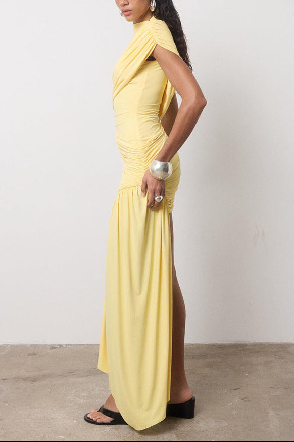 Side view of a yellow ruched mini dress with a high slit, paired with black platform slides.