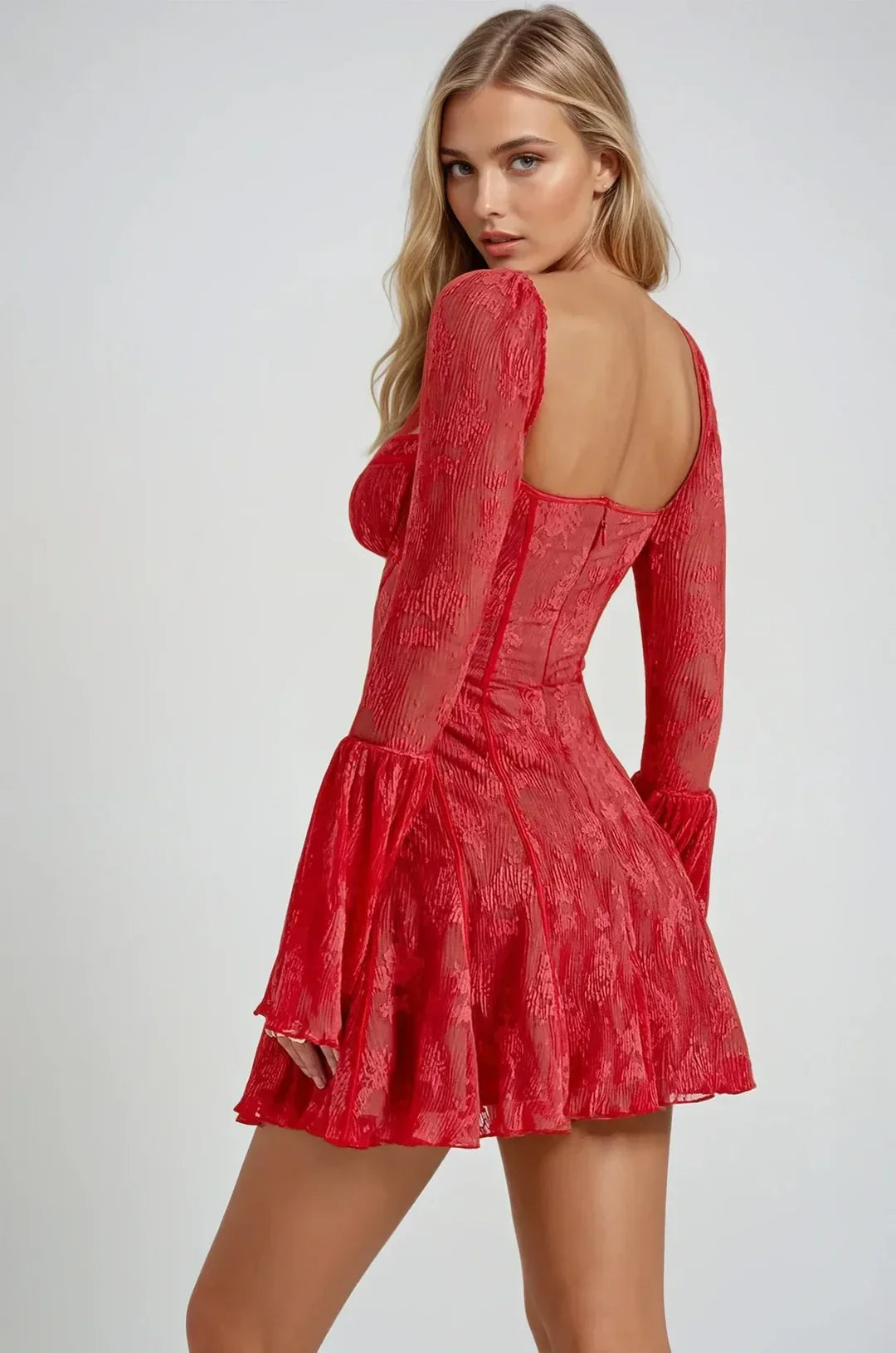 Back view of a woman wearing a red lace mini dress, showing the square back and the flow of the skirt.