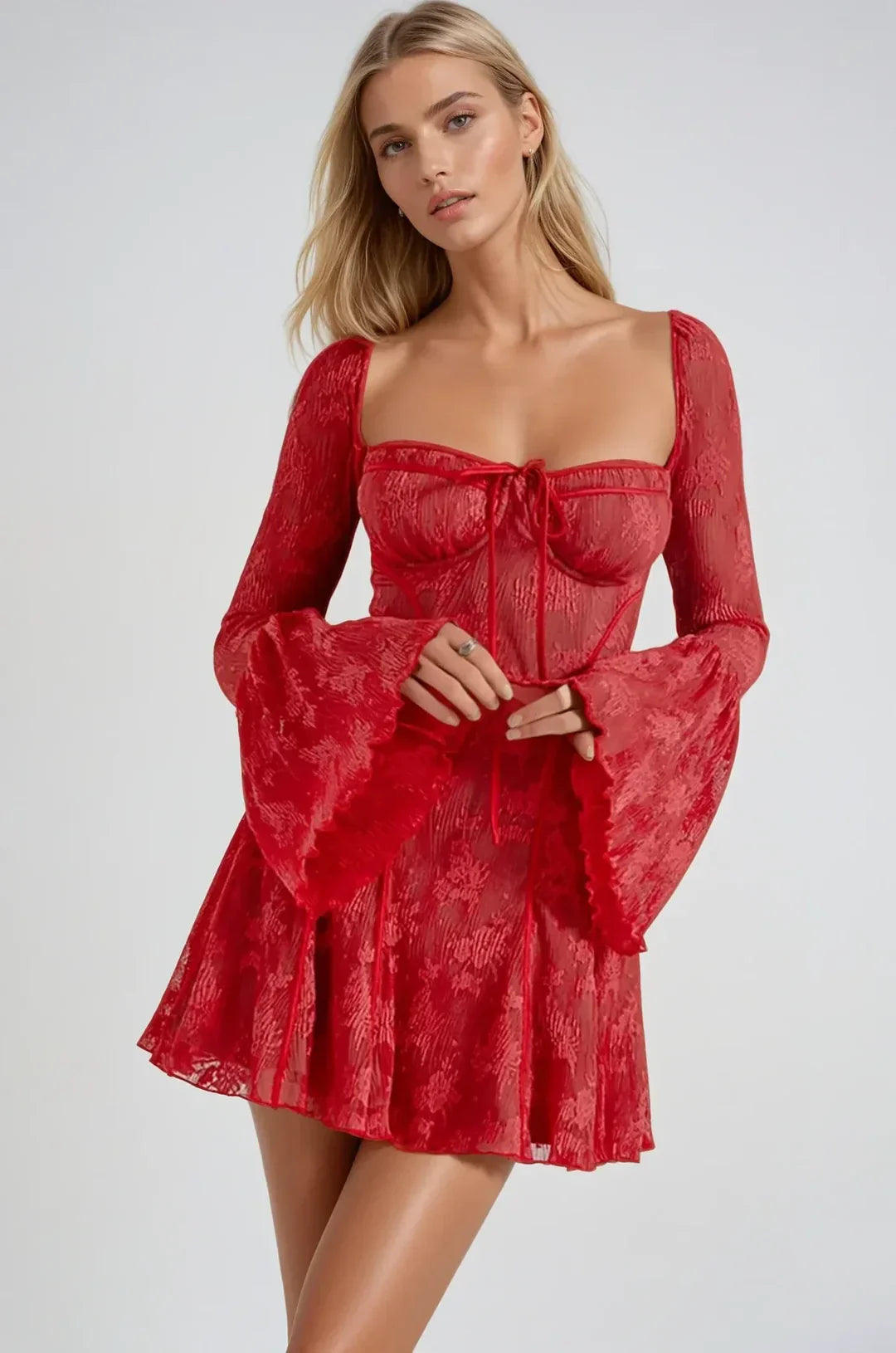 Front view of a woman in a red lace mini dress, with hands clasped, emphasizing the square neckline and bell sleeves.