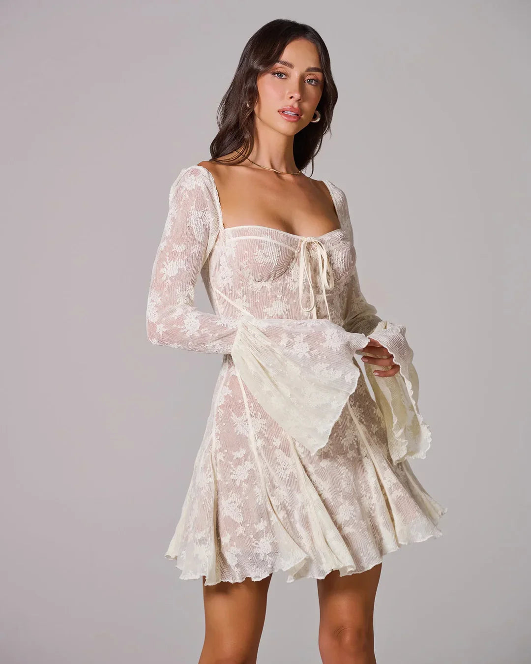 Cream white lace mini dress with long bell sleeves, a square neckline, and a fitted bodice with a front tie detail.