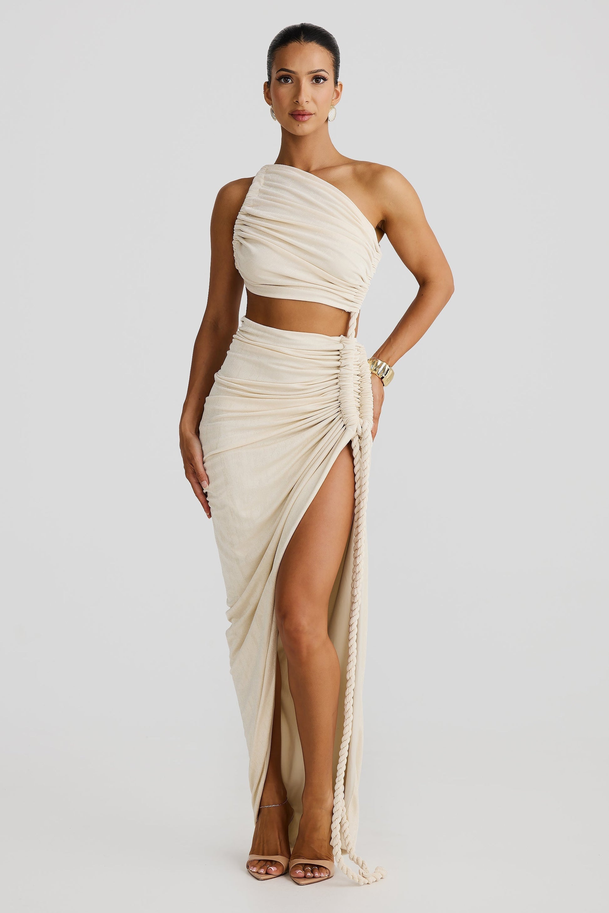 Front view of the cream Aspen Rope Maxi Dress, emphasizing the elegant draping and the functional rope detail creating a high slit.