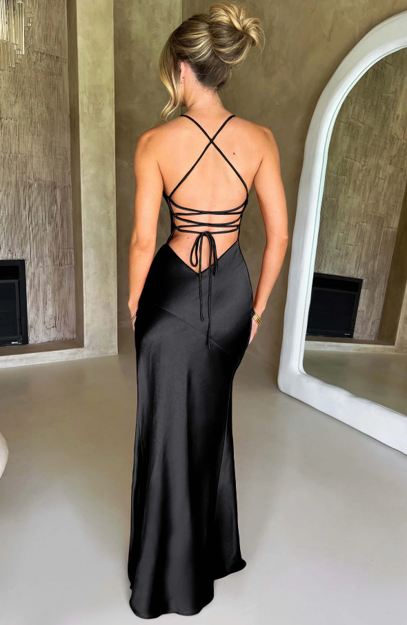 Rear view of the black plunge maxi dress, highlighting the elegant criss-cross back straps and the smooth satin fabric.
