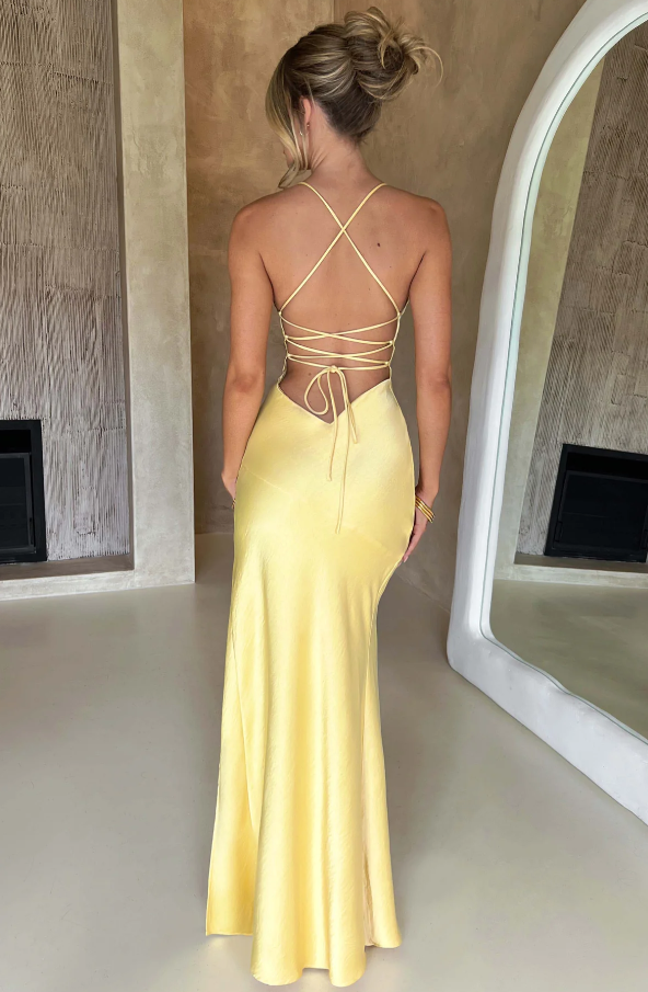 Back view of the yellow plunge maxi dress, showing the intricate criss-cross strap detailing and open back design.