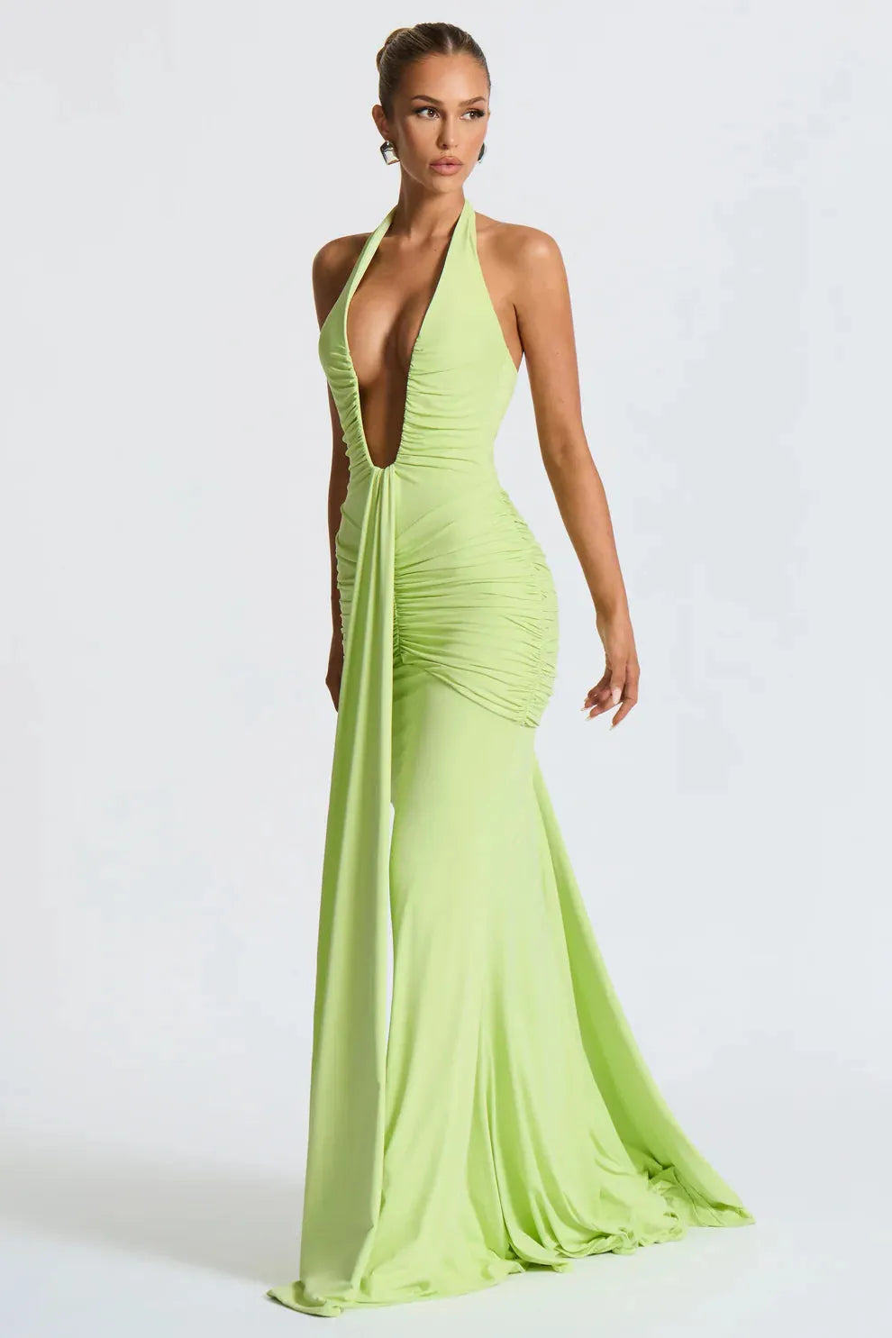 Front view of a lime green Serena ruched maxi dress with a deep plunging halter neckline and long flowing skirt.