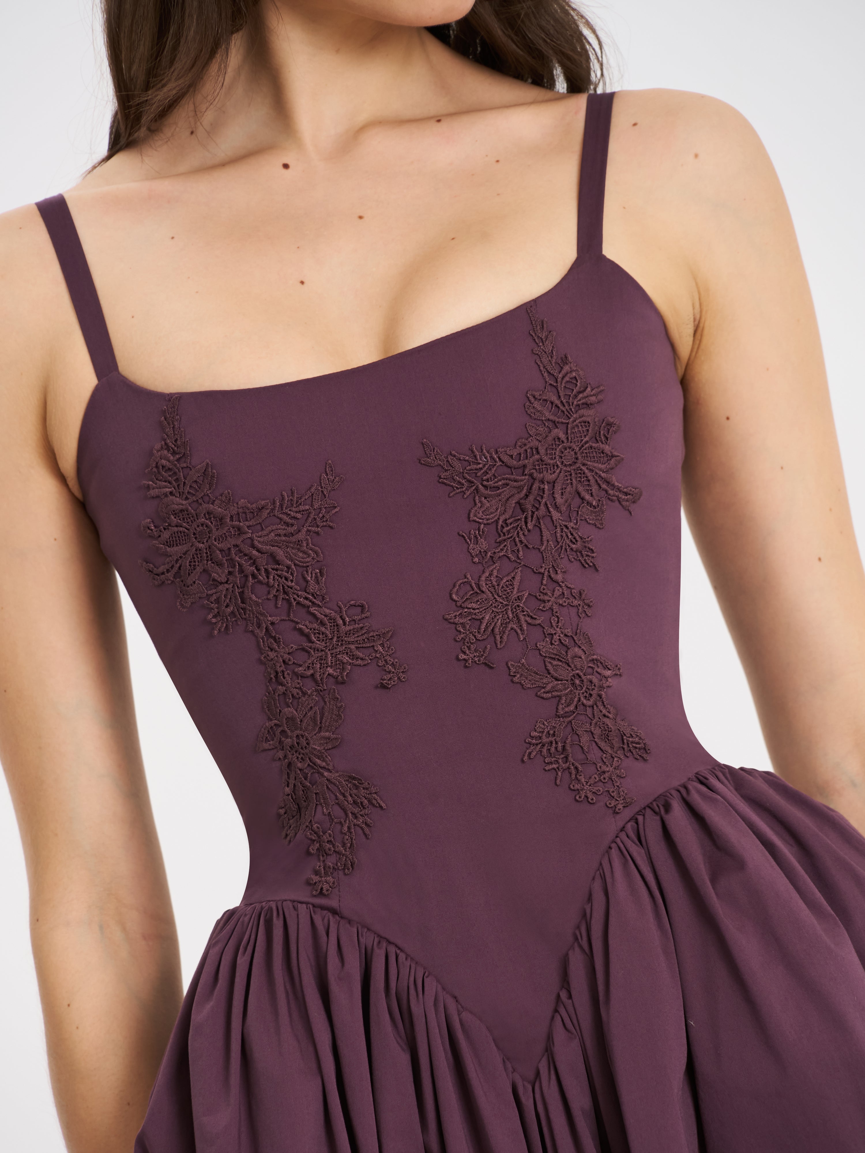 Close-up of the intricate floral embroidery detail on the bodice of the purple midi dress.