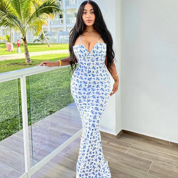 Full-length Brooke Floral Maxi Dress in white with delicate blue floral print and spaghetti straps, showcasing a fitted silhouette.