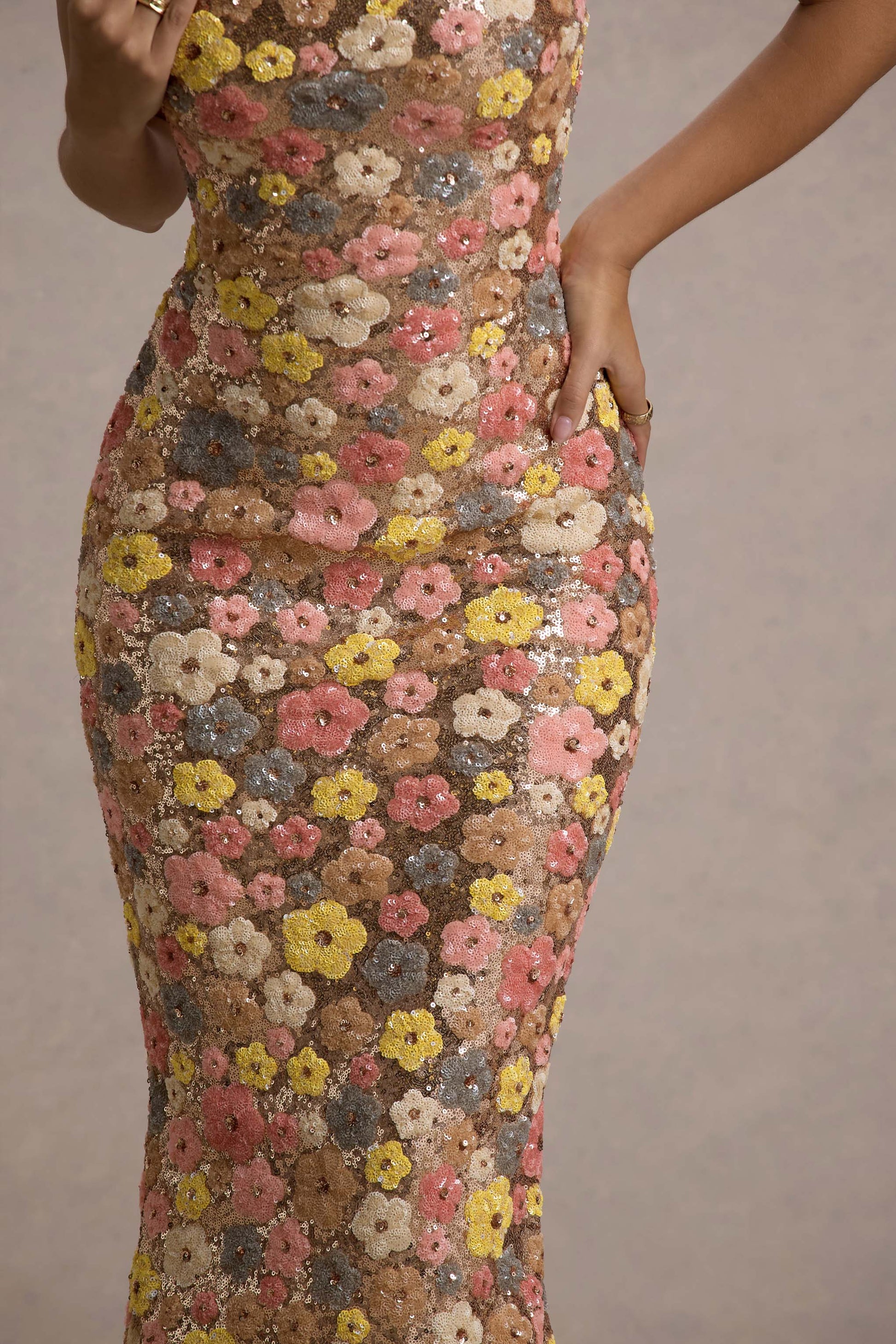Detailed close-up of the pink, yellow, and grey floral sequin pattern on the maxi dress fabric