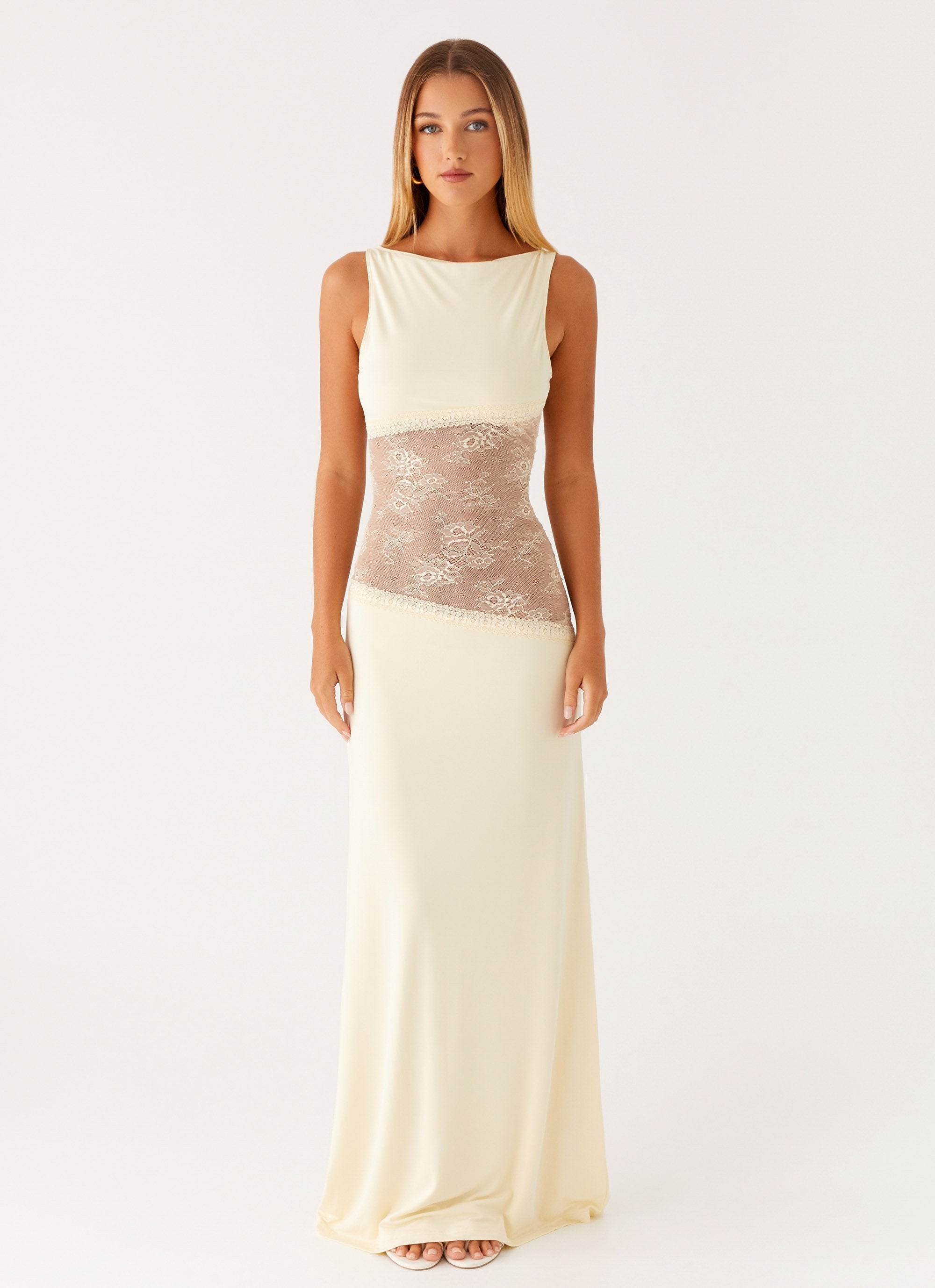 Cream-colored Camille Lace Maxi Dress with sheer lace midsection and boat neck, flowing design.