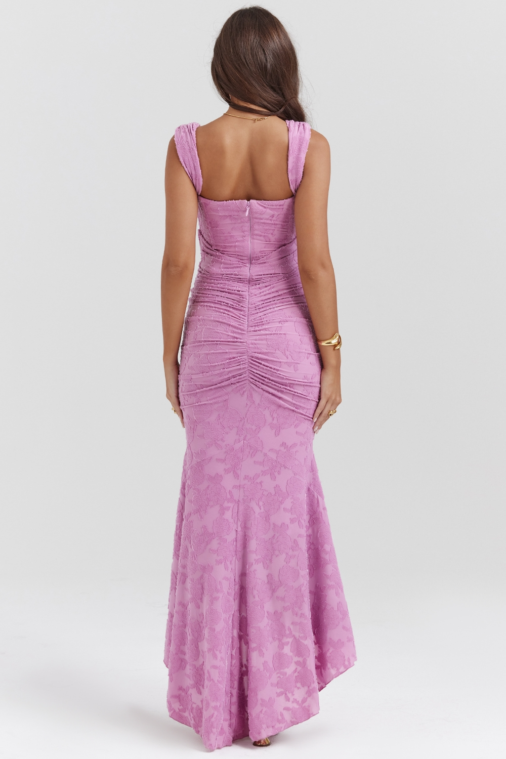 Back view of an orchid purple floral jacquard corset maxi dress, highlighting the ruched detailing and high-low hem.