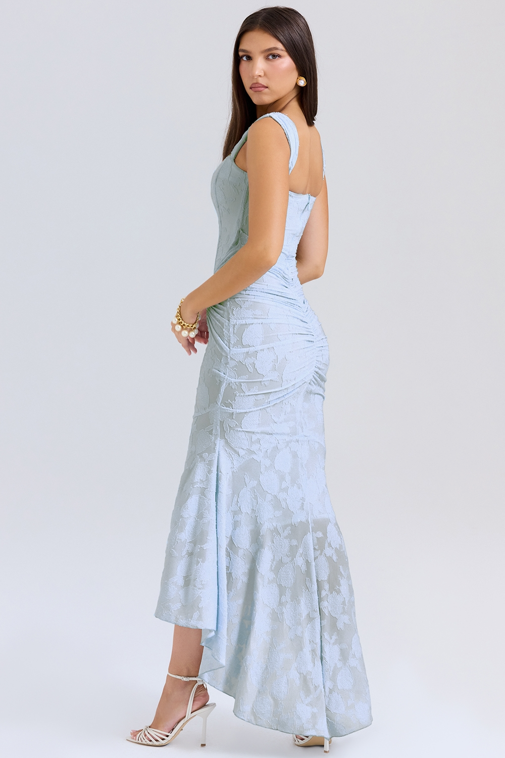 Side view of the light blue Carie corset maxi dress, showing the ruched back and high-low mermaid-style skirt.