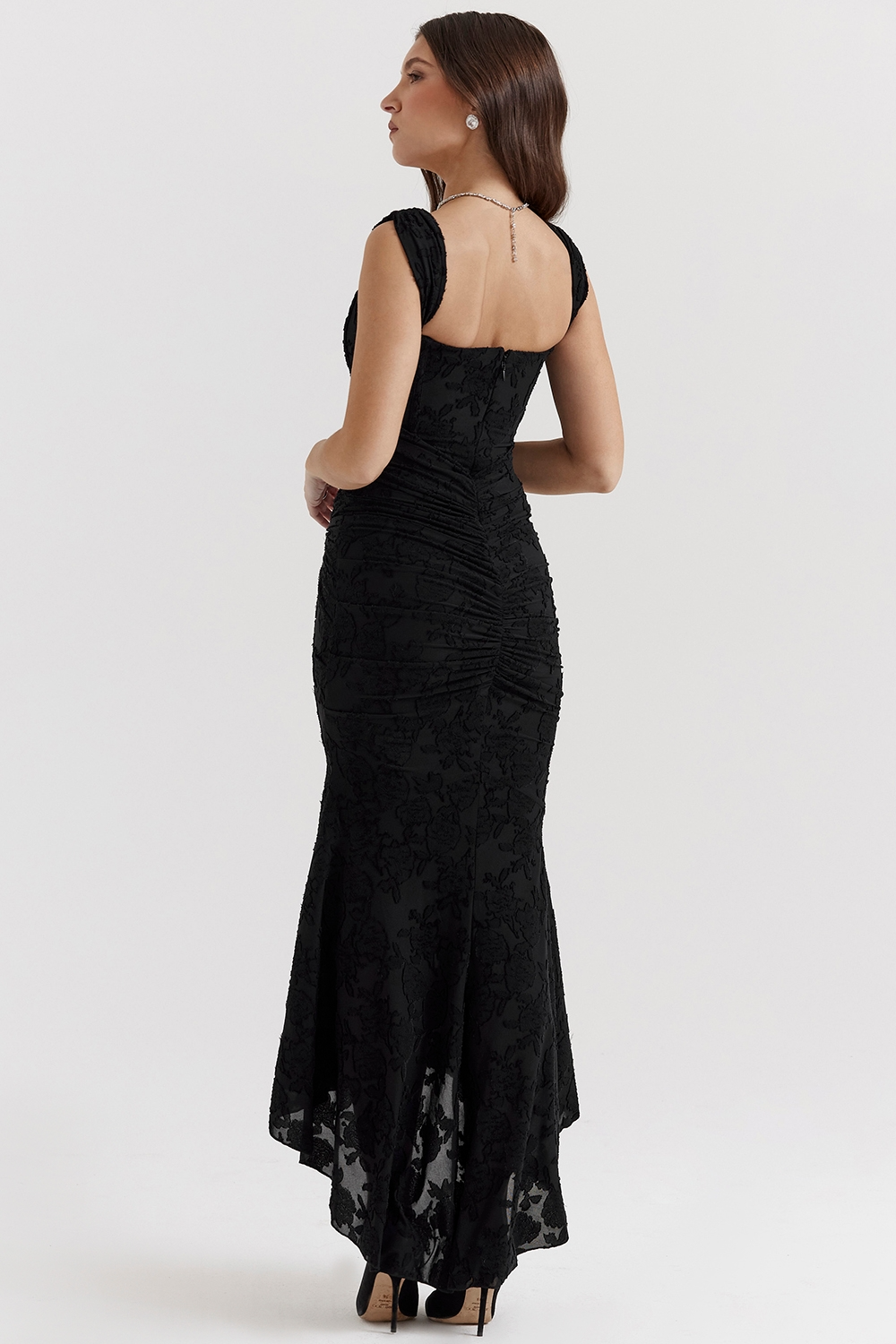 Side view of the black Carie corset maxi dress, showing the elegant silhouette and ruched back detail.