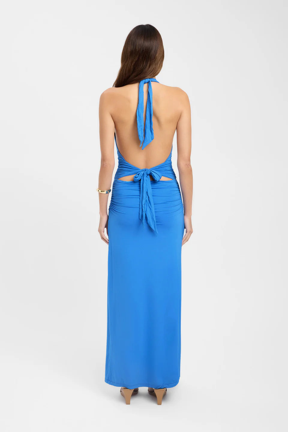 Back view of a women's Cassandra Ruched Maxi Dress in bright blue, featuring a halter neck and tie-back detail.