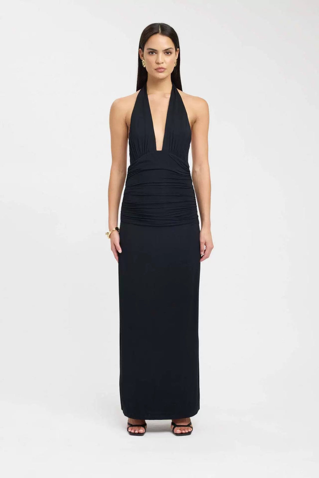 Front view of a dark brown ruched maxi dress with a deep V-neck halter top and a long, flowing skirt.