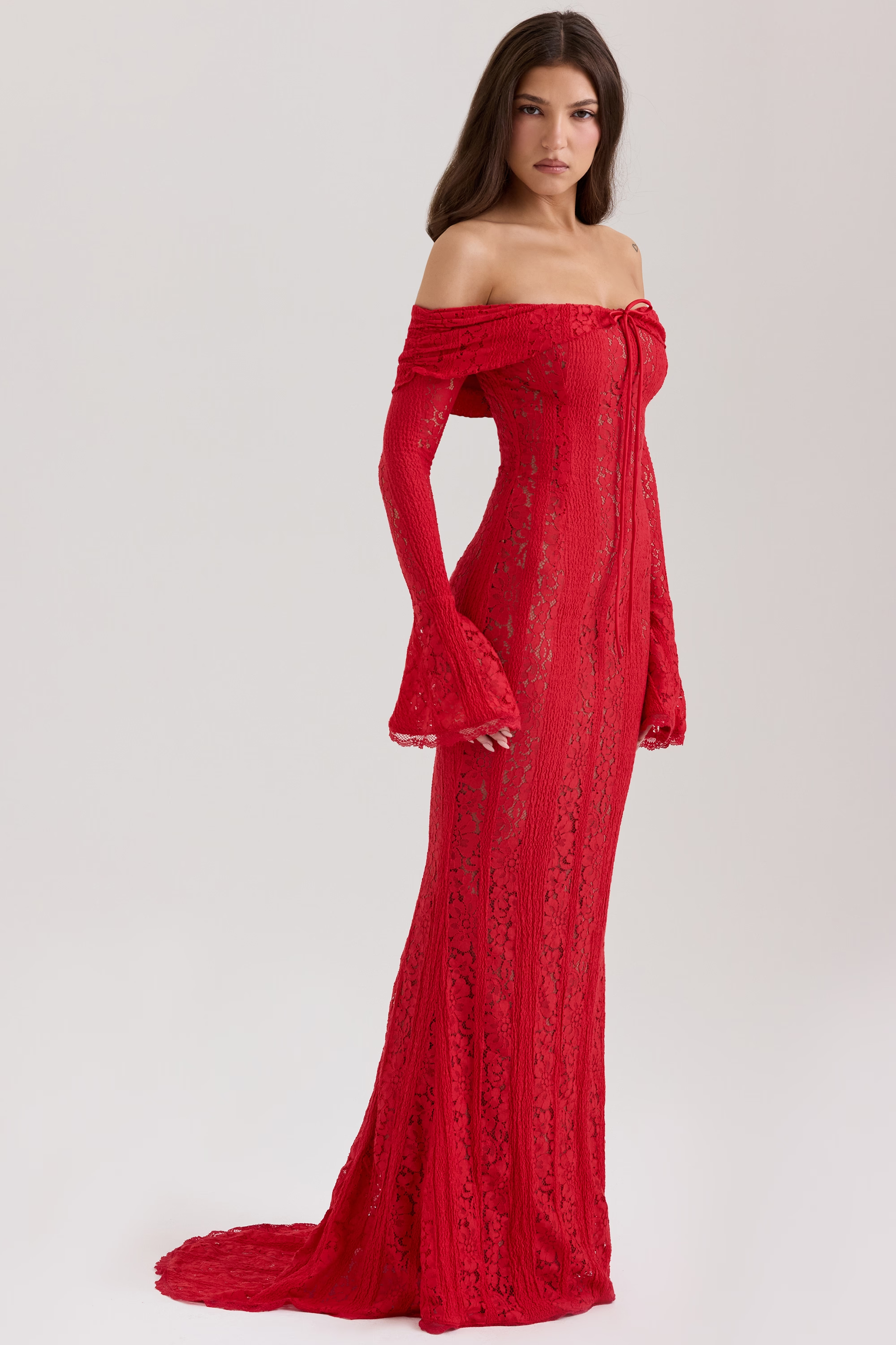 Side profile of a woman in a red lace maxi off-shoulder dress with flared sleeves for formal events