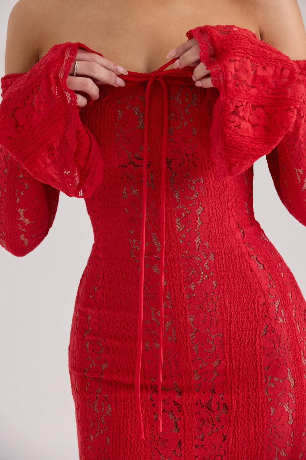 Close-up of the red lace fabric detail and tie-front on an off-shoulder maxi dress for women