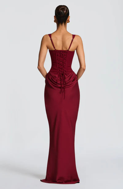 Back view of a rich burgundy Celeste corset maxi dress featuring a full lace-up corset and draped skirt.