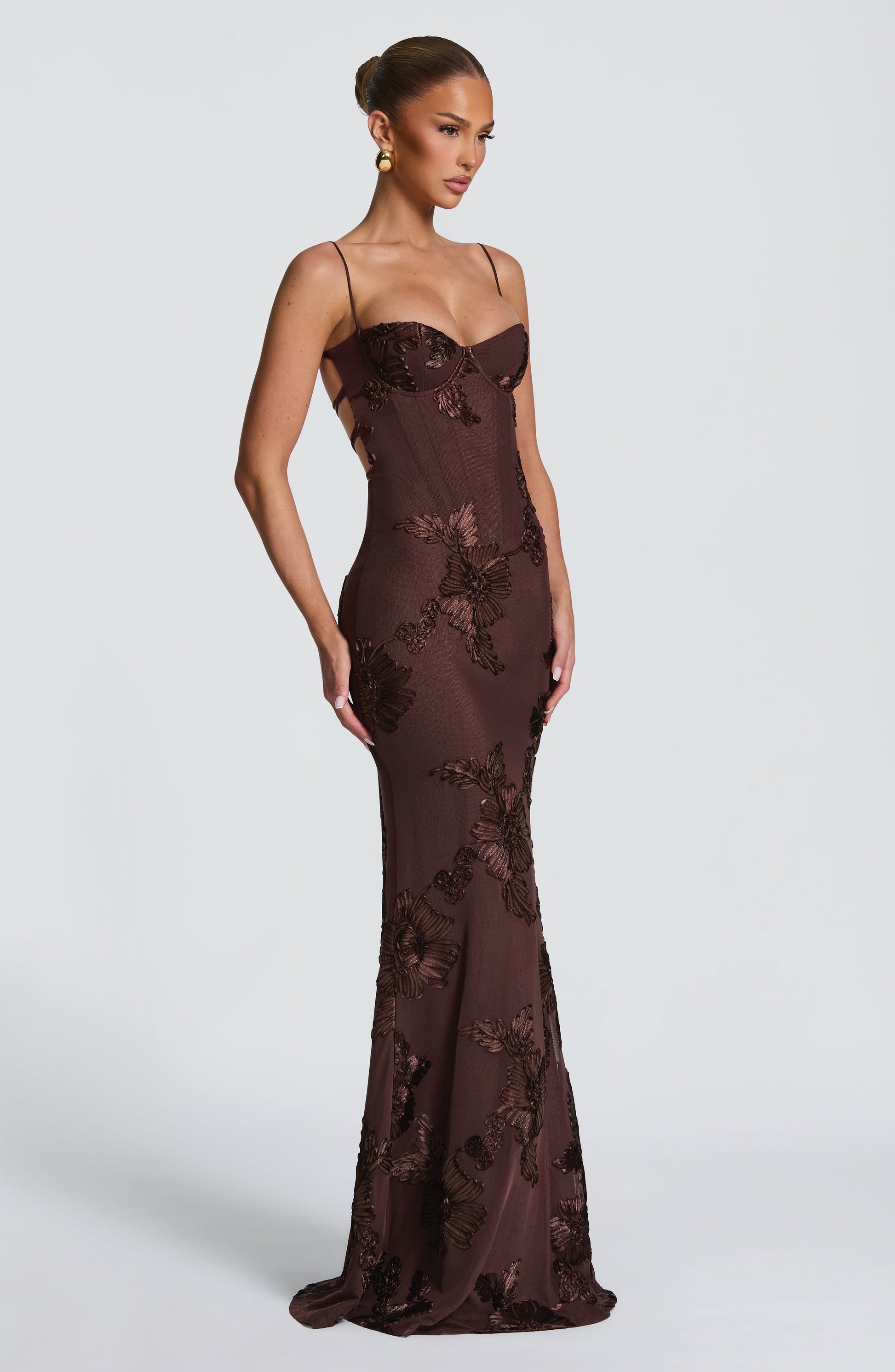 Side profile of a brown floral maxi dress, highlighting the fitted silhouette and flowing skirt, suitable for plus size prom gowns.