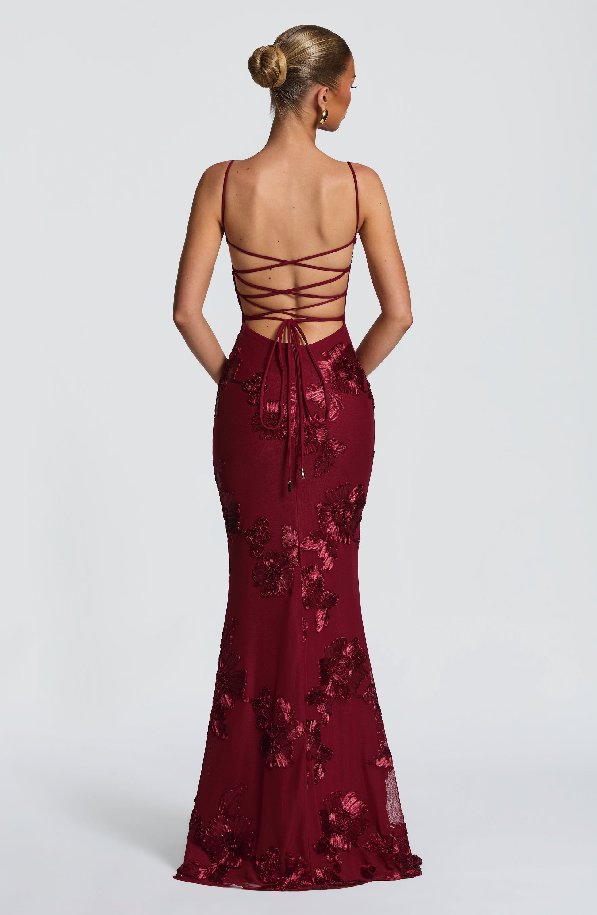 Back view of a deep red floral maxi dress featuring a criss-cross lace-up back and intricate floral embroidery, perfect for formal clothes.
