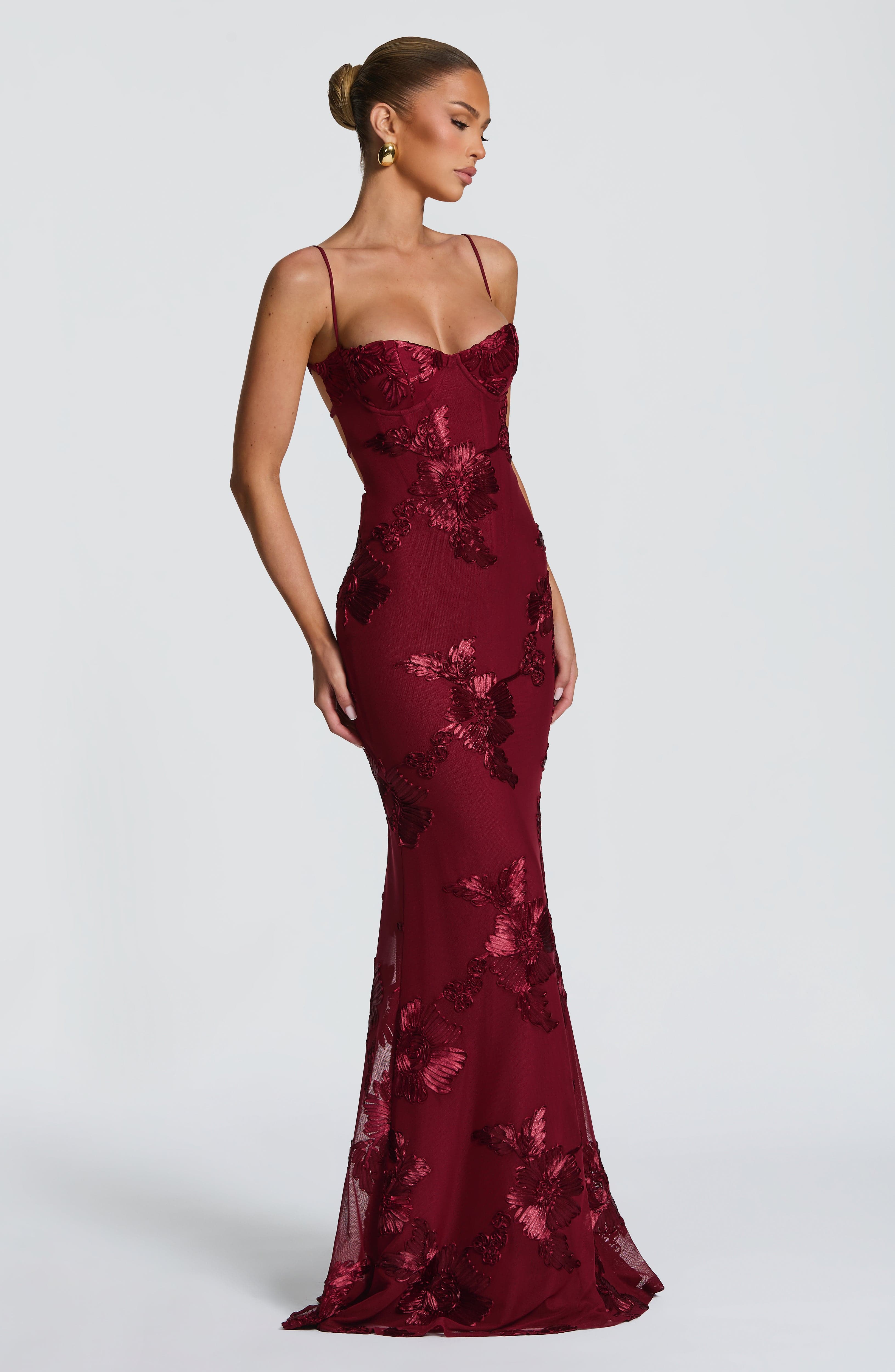 Side view of a deep red floral maxi dress, showcasing the form-fitting design and elegant floral details, suitable for plus size formal clothing.