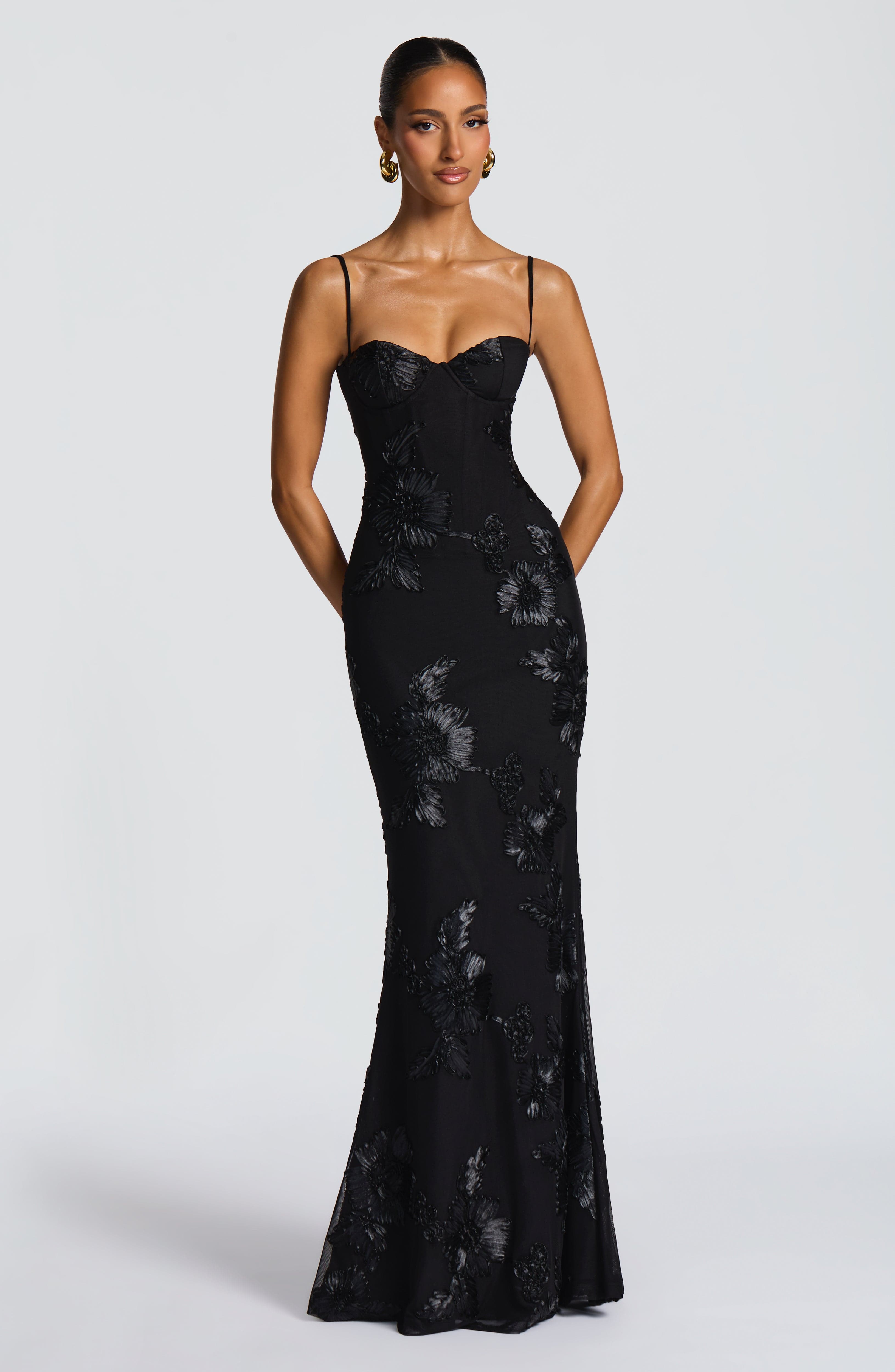 Front view of a black Celestina Floral Maxi Dress, featuring delicate straps, a sweetheart neckline, and intricate floral appliqué details.
